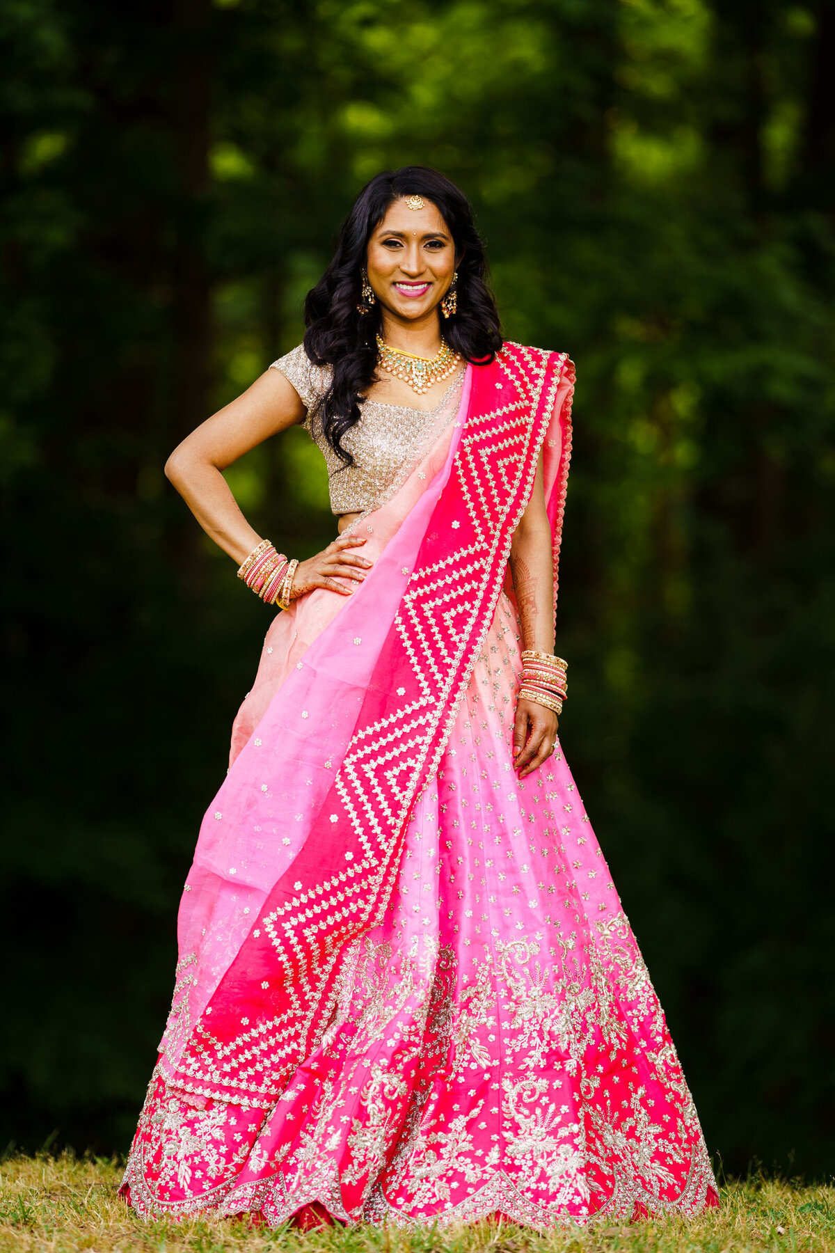 A woman in a traditional Indian outfit with one hand on her hip.