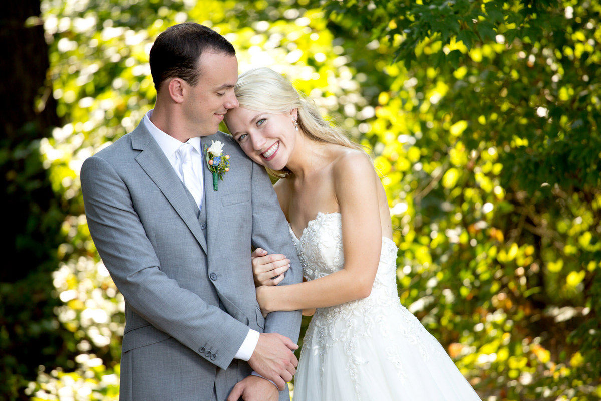 Couple smiles for an outdoor portrait at Hidden Acres wedding venue