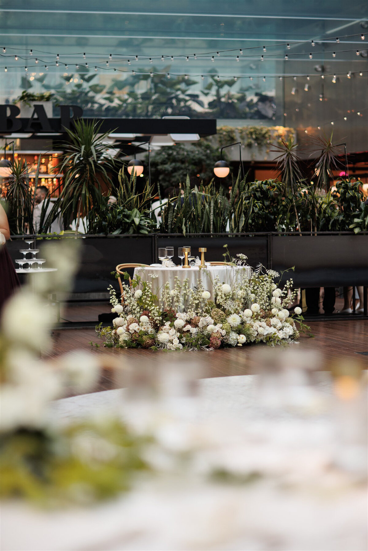 Elaborate floral arrangements surround the front of a sweetheart table for a Cathcart wedding reception.