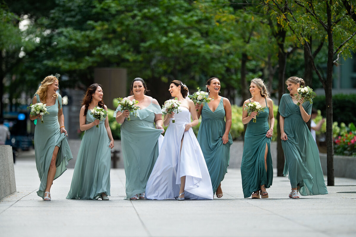 bridesmaid in green mint tiffany color dressing walking  and laughing with the bride in the middle
