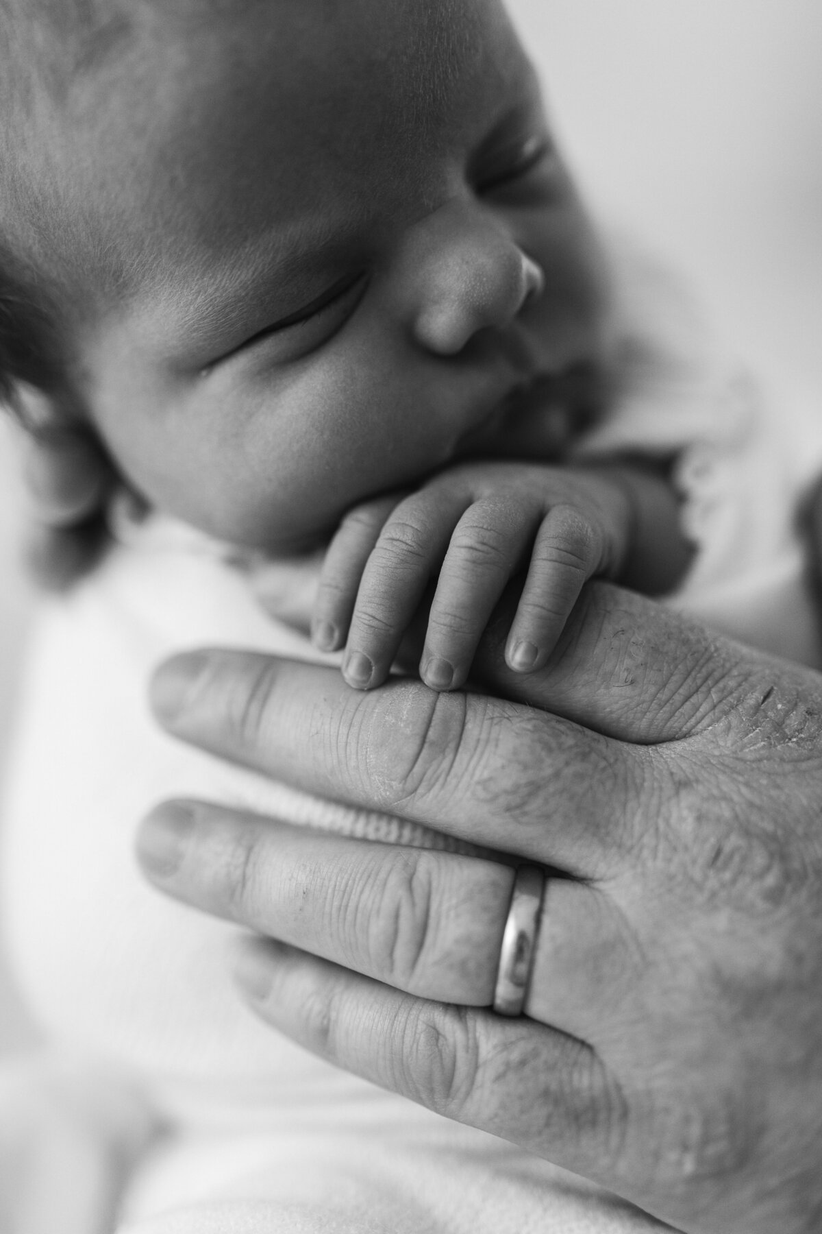 Baby holding dads hand photo in black and white