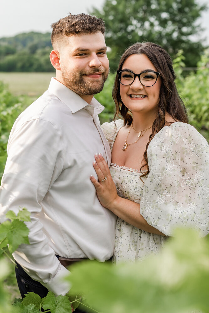 Couple smiling while standing in a colorful vineyard