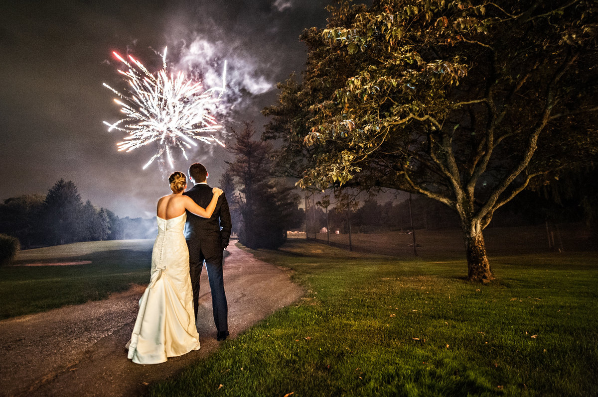 A bride and groom enjoy a firework show at their wedding at Penn Oaks Golf Club.