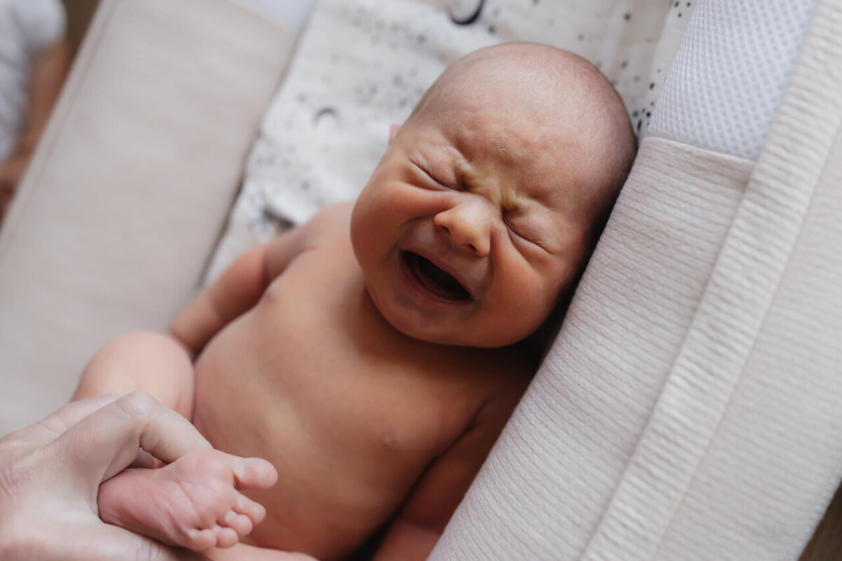 Kraamreportage baby wordt verschoond en moet huilen