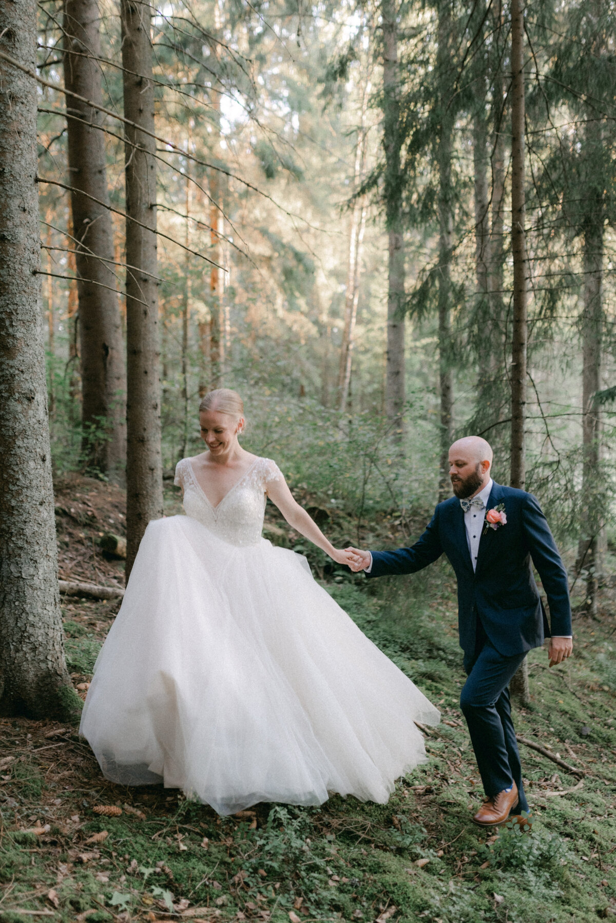 Hääkuvaajan ohjaama romanttinen hääkuva hääparista metsässä