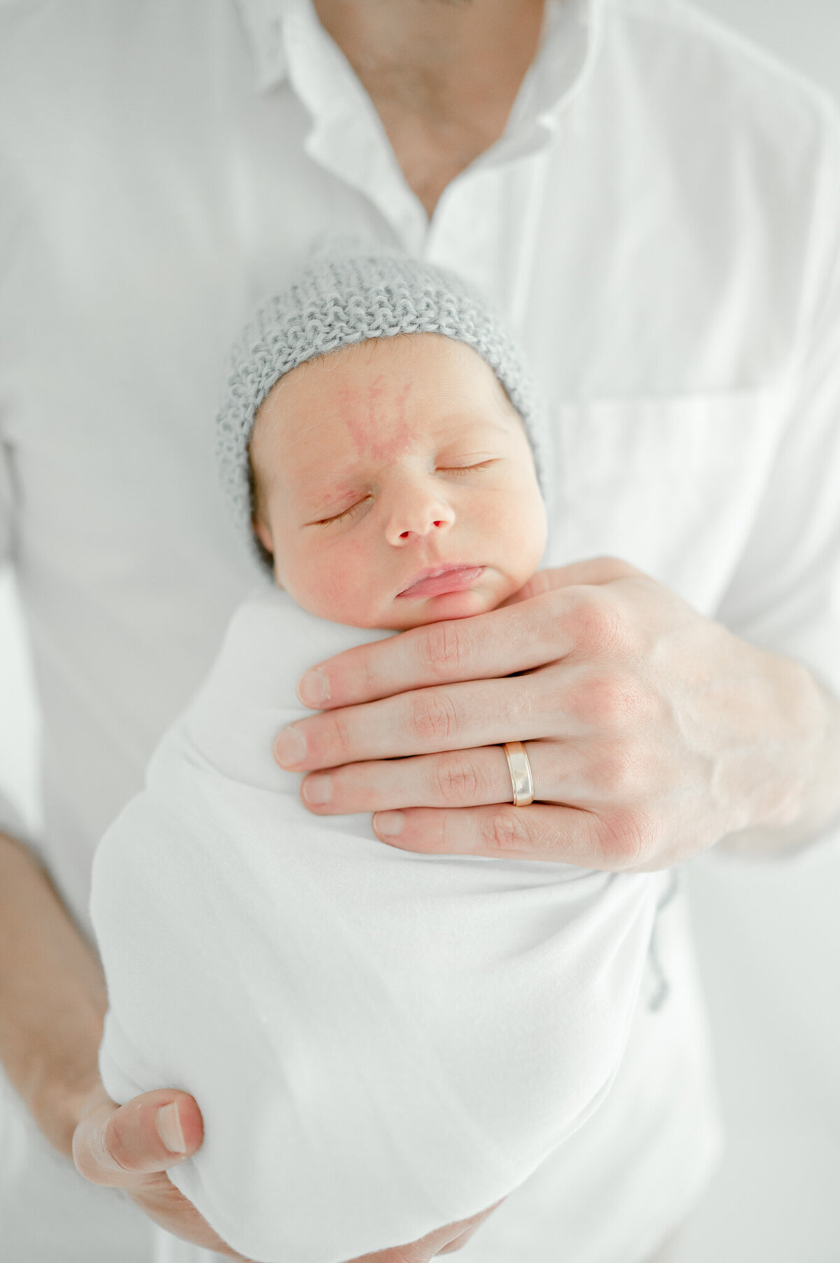 baby in a blue bonnet sleeps In Kristie Lloyd’s Nashville newborn photographer studio