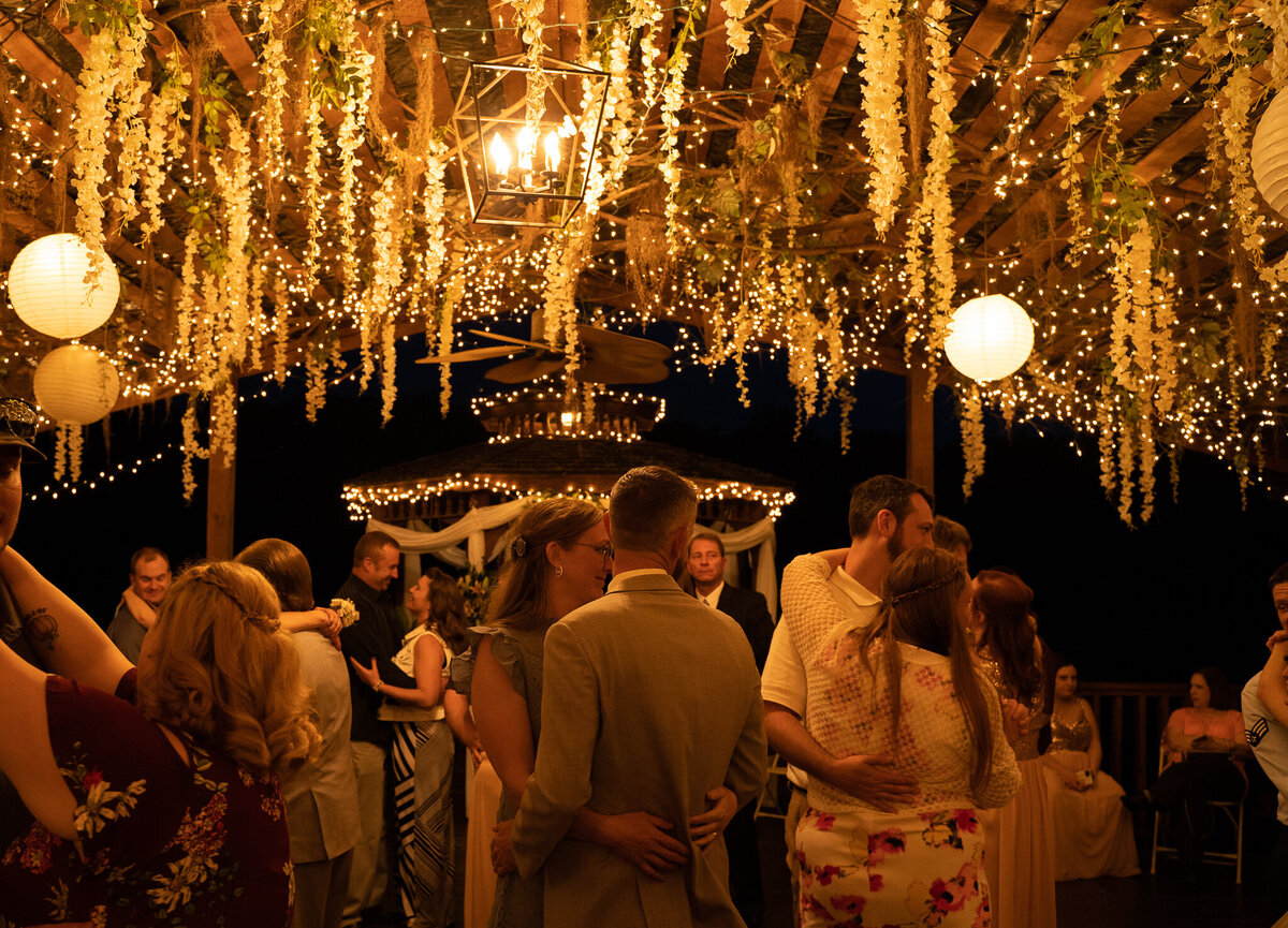 Couples dance under the romantic lights and cascading flowers at Amber and Beau Atchley's wedding at Cheers Chalet in Lancaster, Ohio.