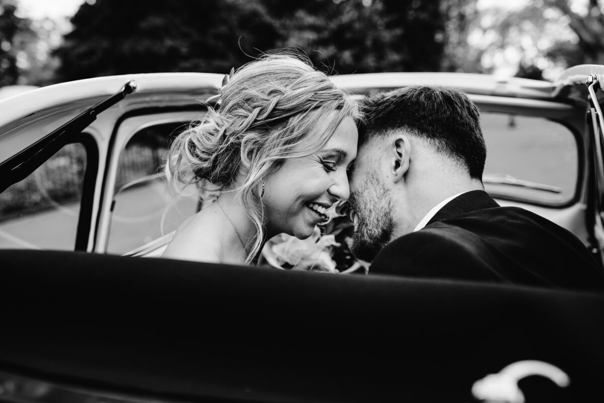 Black and white close up photo of couple in convertible car