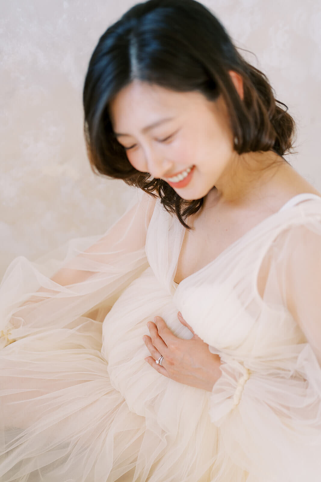 Witness the grace of a Chinese Australian mum's pregnancy journey as she shines in a stunning cream tulle gown at a Gold Coast studio.