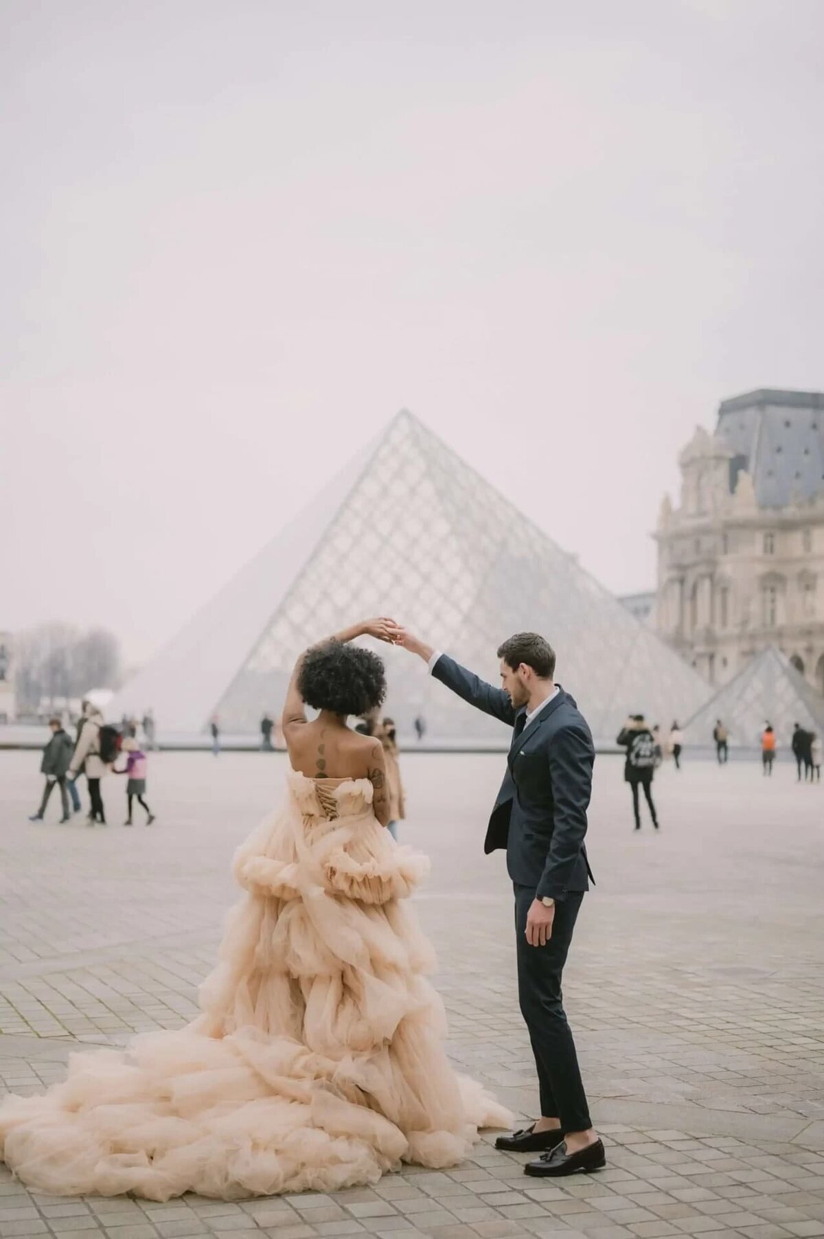 a couple having a photoshoot at the Louvre, in Paris