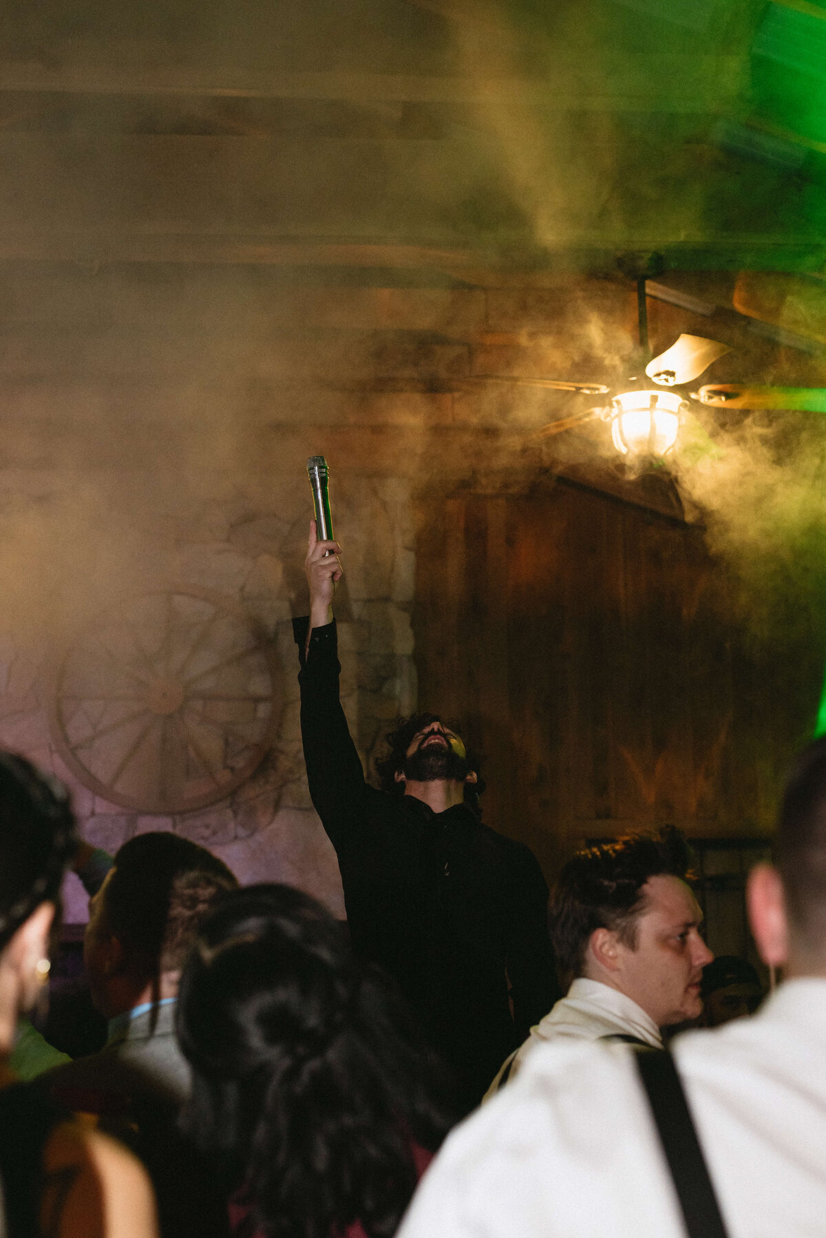 wedding reception in a barn with smoke and lights and guests dancing