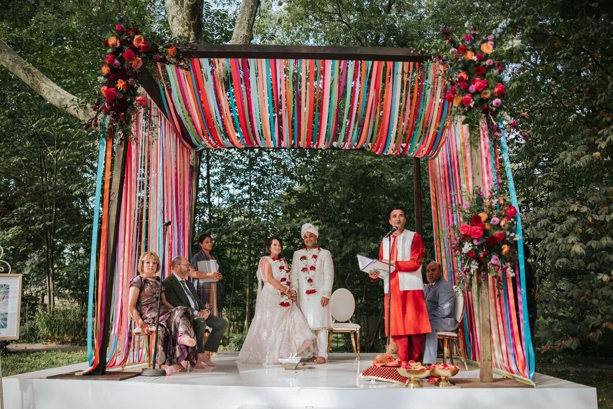 Bride and Groom awaiting to be married under the mundup chuppah in Philadelphia.