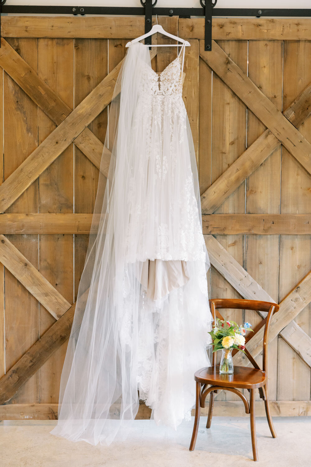 Brides dress hanging on the wooden wall