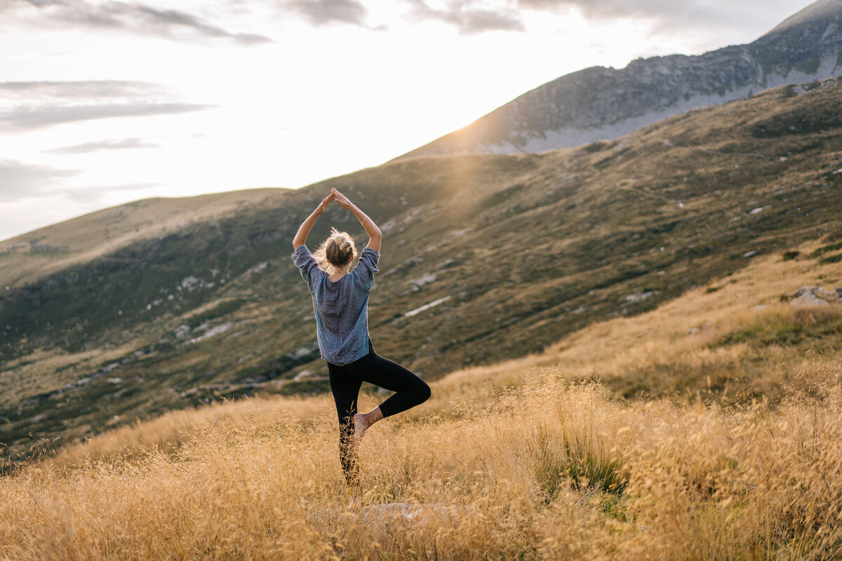 Young-woman-preforms-yoga-in-mountains-in-morning-light-1177855476_5904x3936