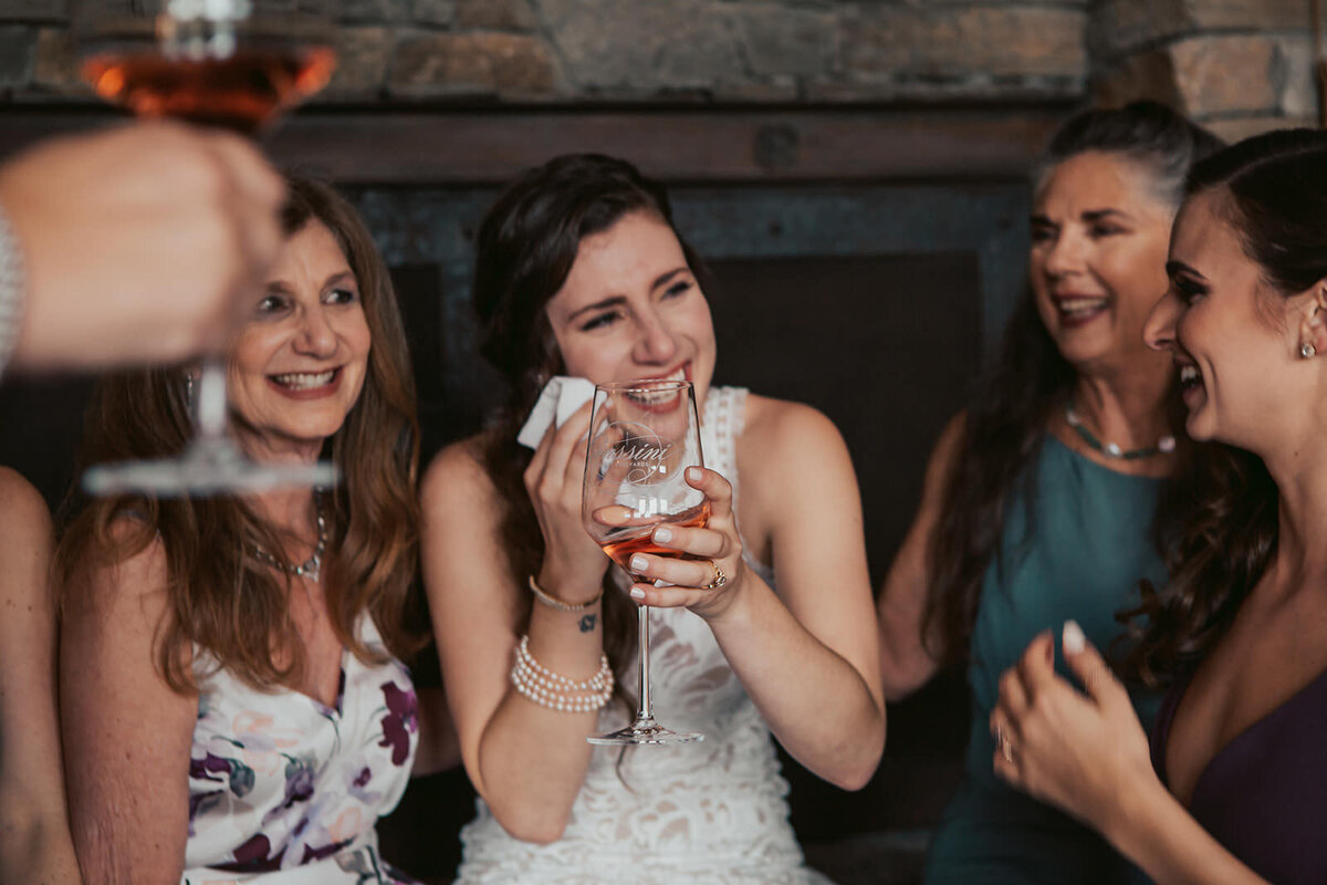 A newlywed laughing and crying with wedding guests 