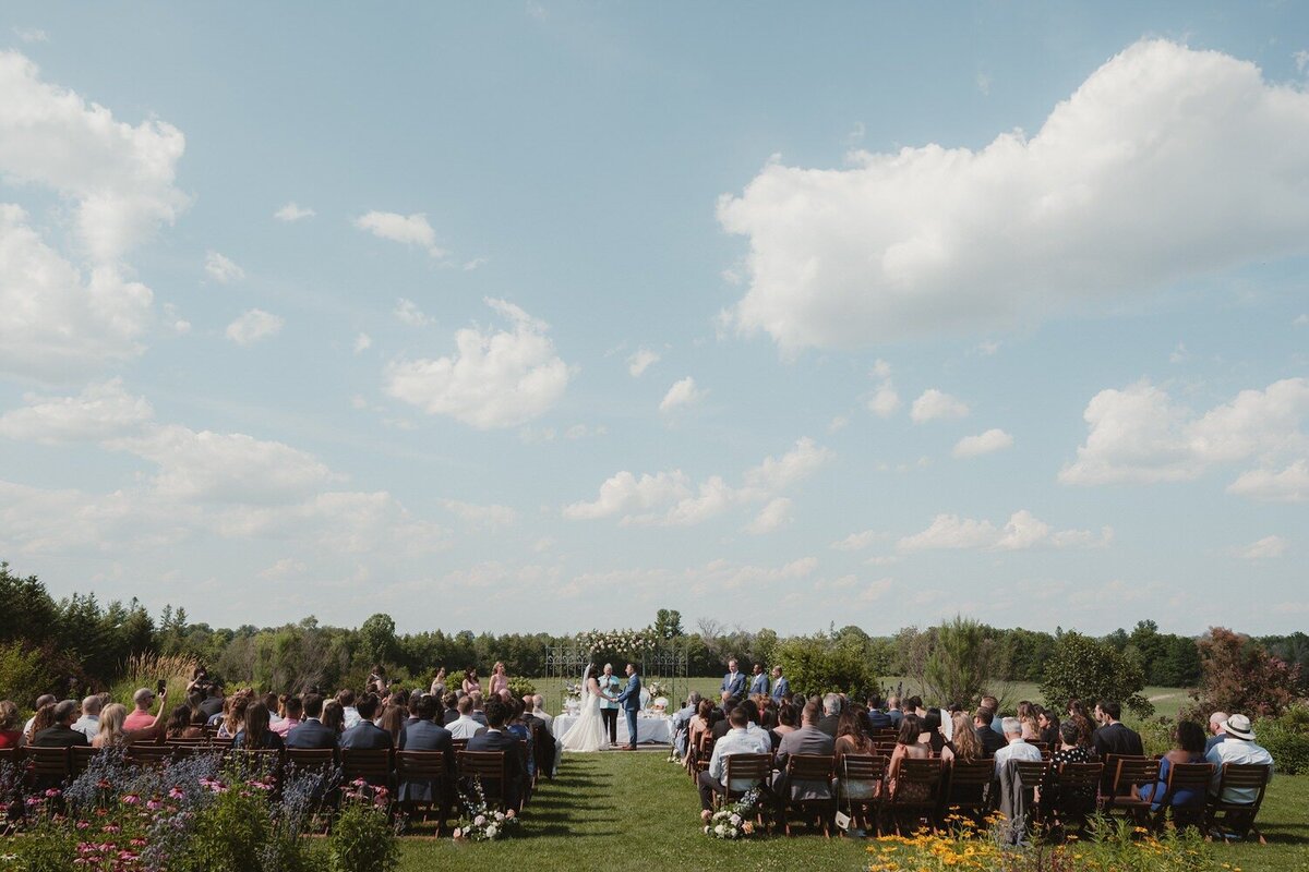extravagant ceremony at evermore on a blue sky sunny day surrounded by flowers