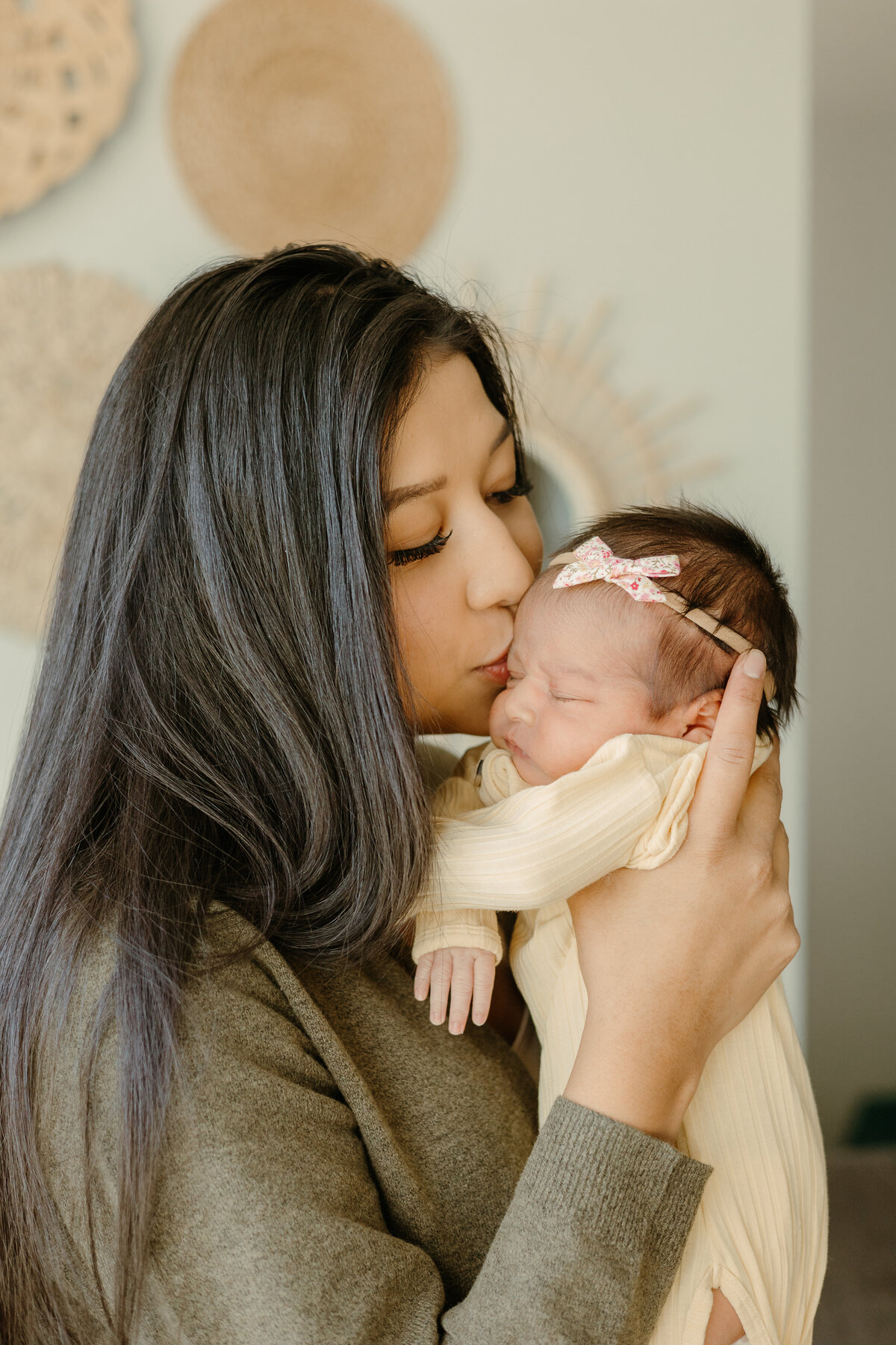 Mom kissing newborn baby on cheek in Longmont Colorado