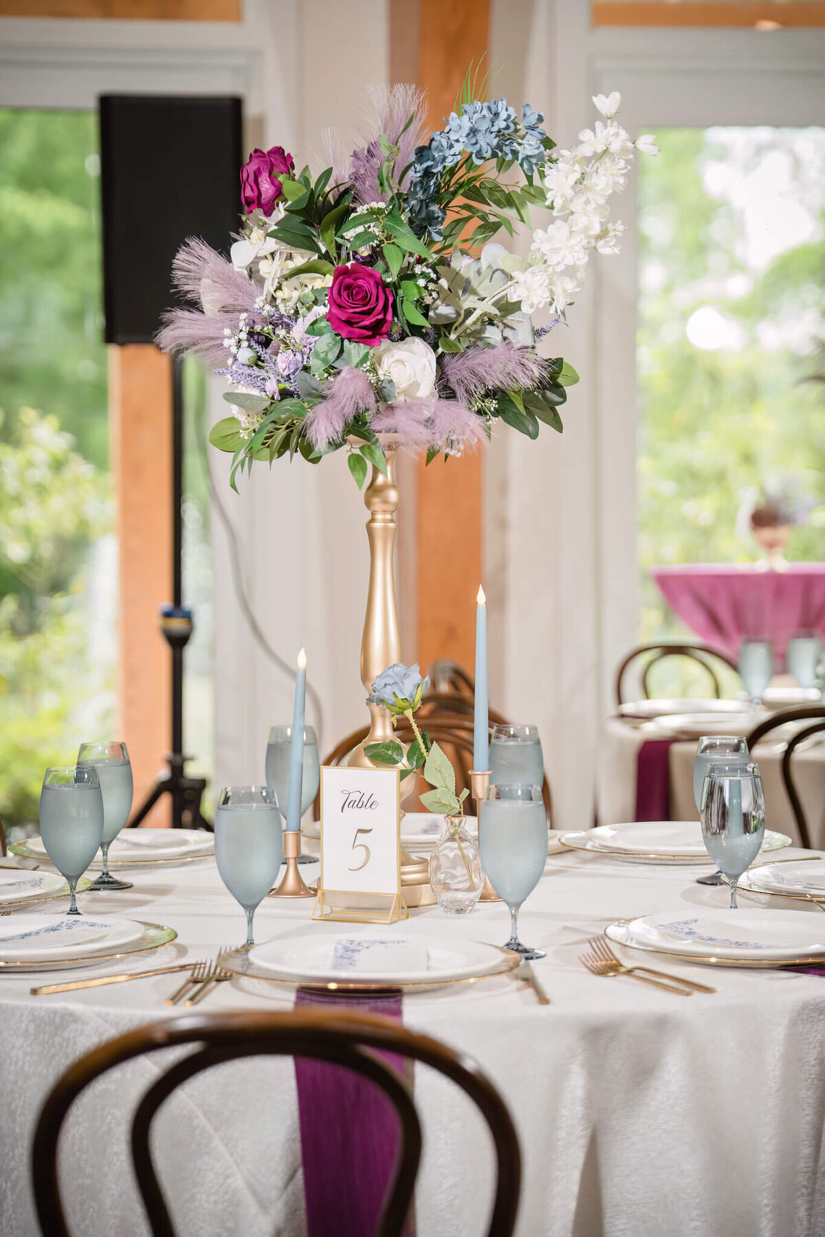 Luxurious wedding centerpiece with purple and white florals at an upscale reception.