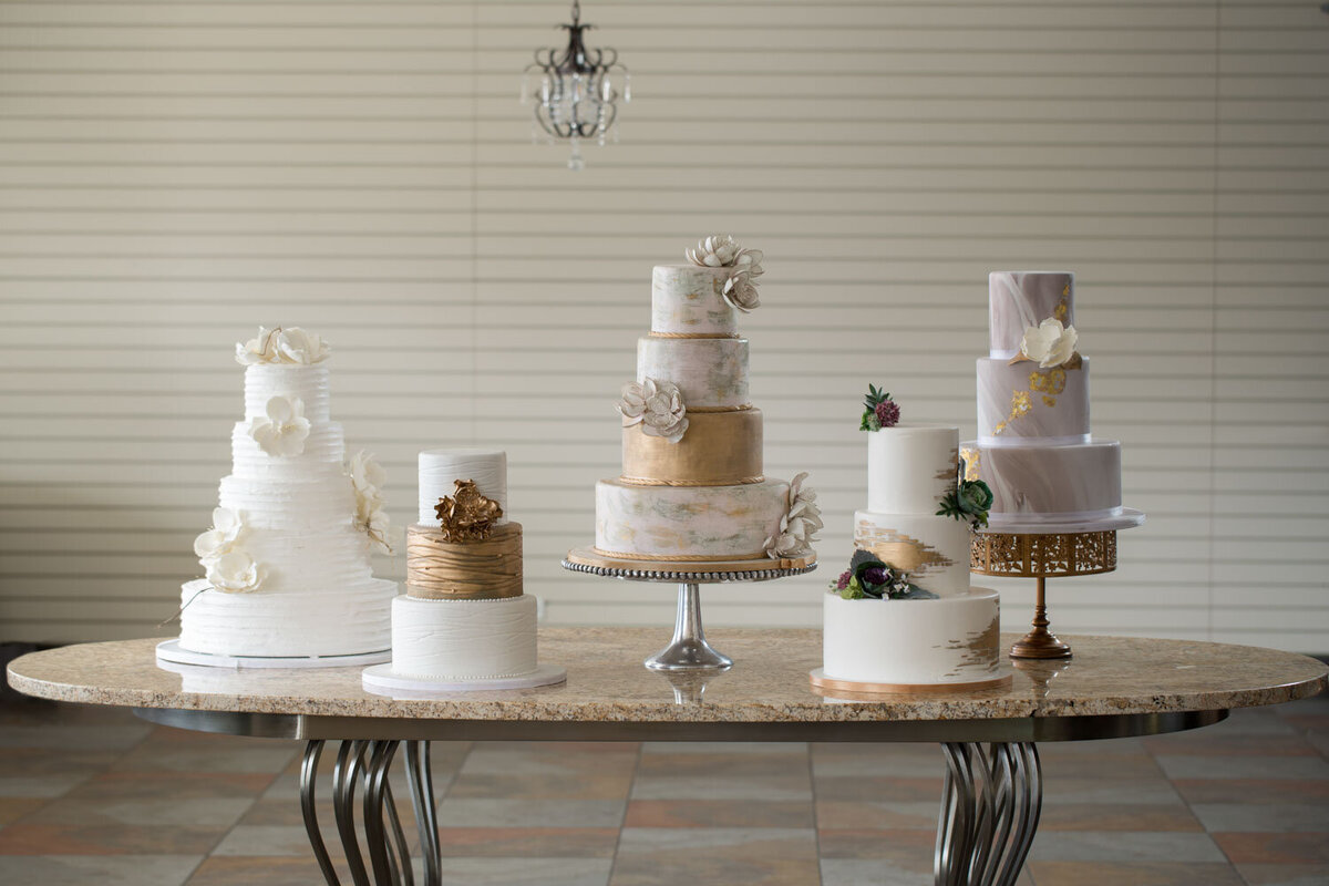 Assorted tiered wedding cakes on display table
