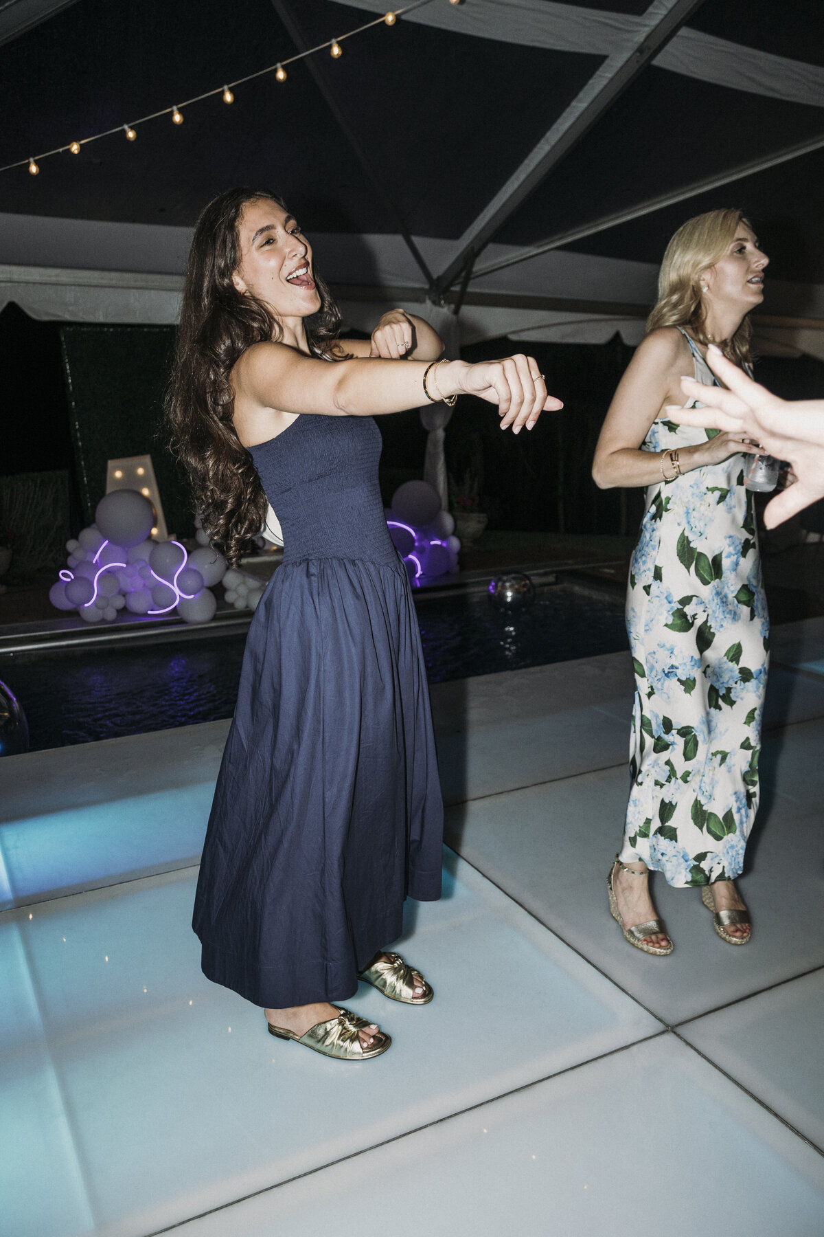 Photo of guests dancing on neon blue dance floor in private backyard party by Mira Park Photography NY based wedding photographer