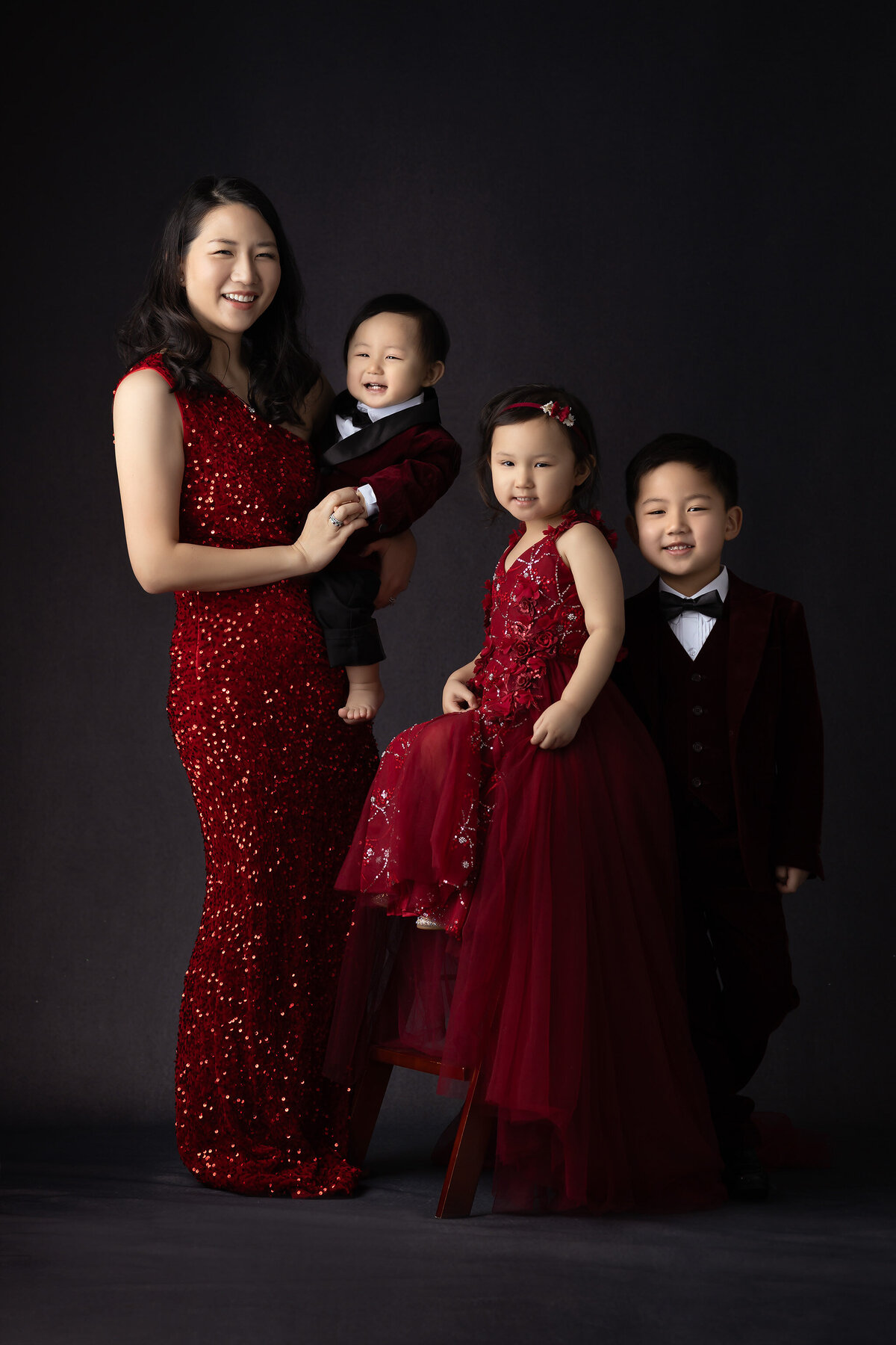 Dallas milestone photographer captures a family in matching red attire for a luxurious portrait.