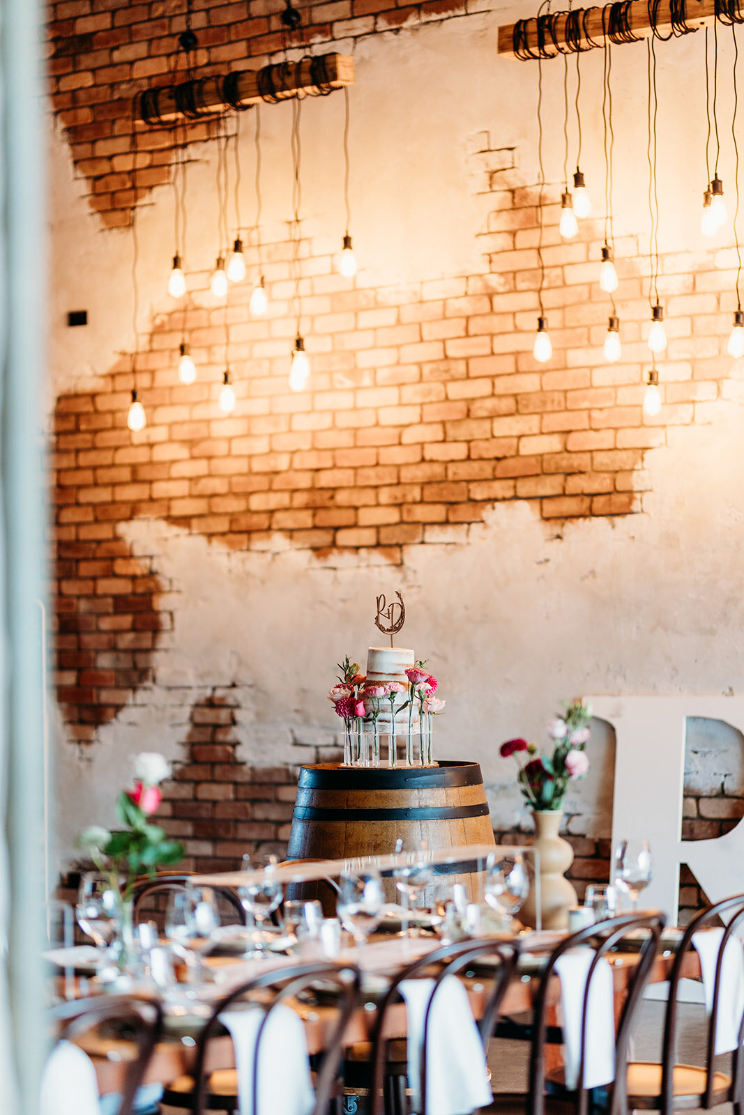 View of wedding cake across the reception space at Petrichor Farm