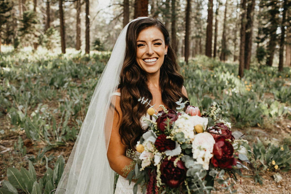 Tahoe Wedding Planners bride holding burgundy and white bouquet at summer wedding venue Mitchell's Mountain Meadows Sierraville near Truckee, Joy of Life Events image by Lukas Koryn
