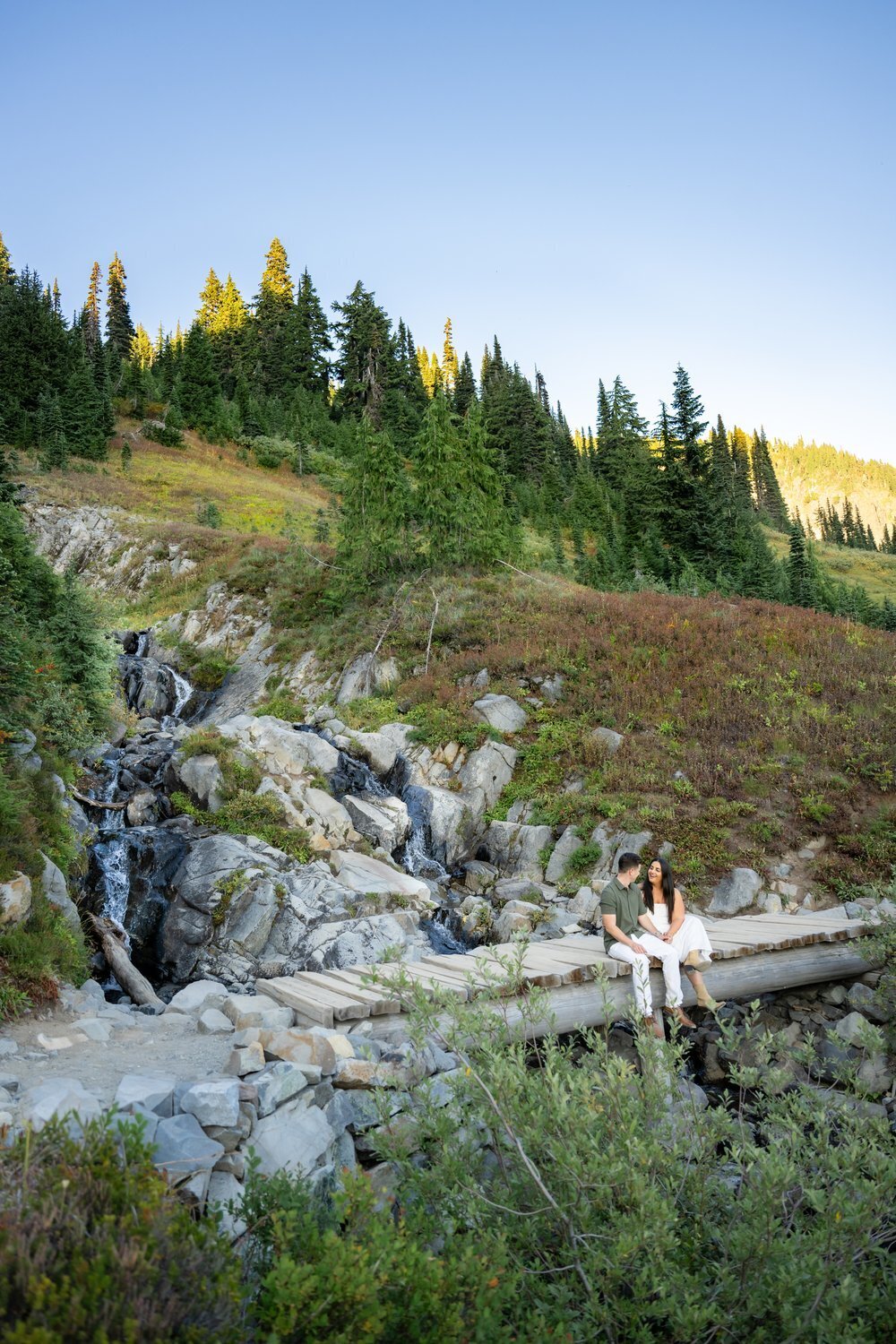 mount rainier elopement fall man and woman sit on bridge