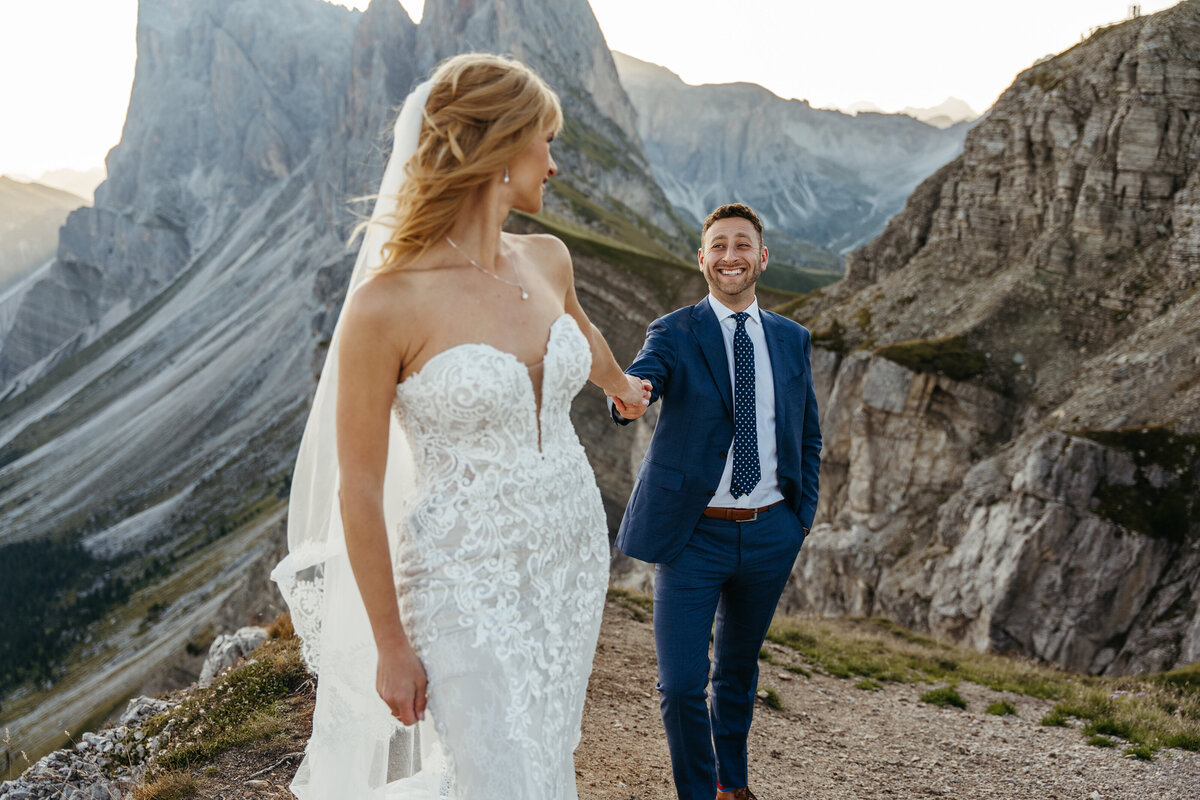 Couple holding hands on mountain ridge at sunrise