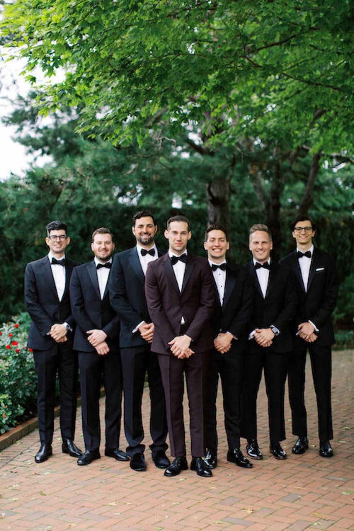 Groomsmen in black tie custom tuxedos for a luxury Chicago outdoor garden wedding.
