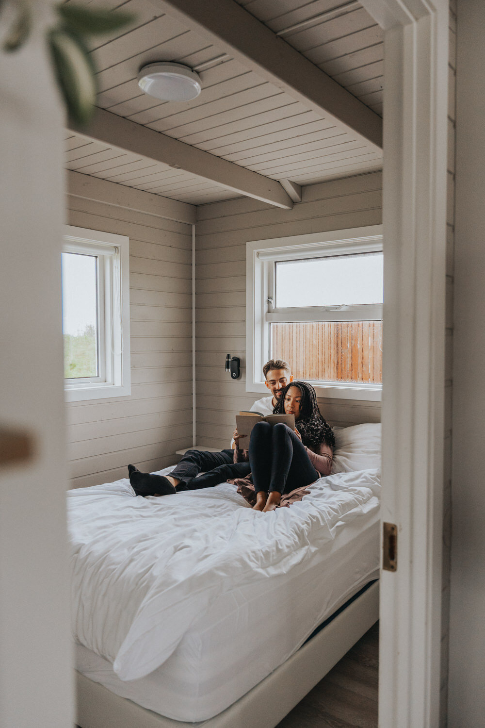 Husband and wife lay on a bed rereading their vows 