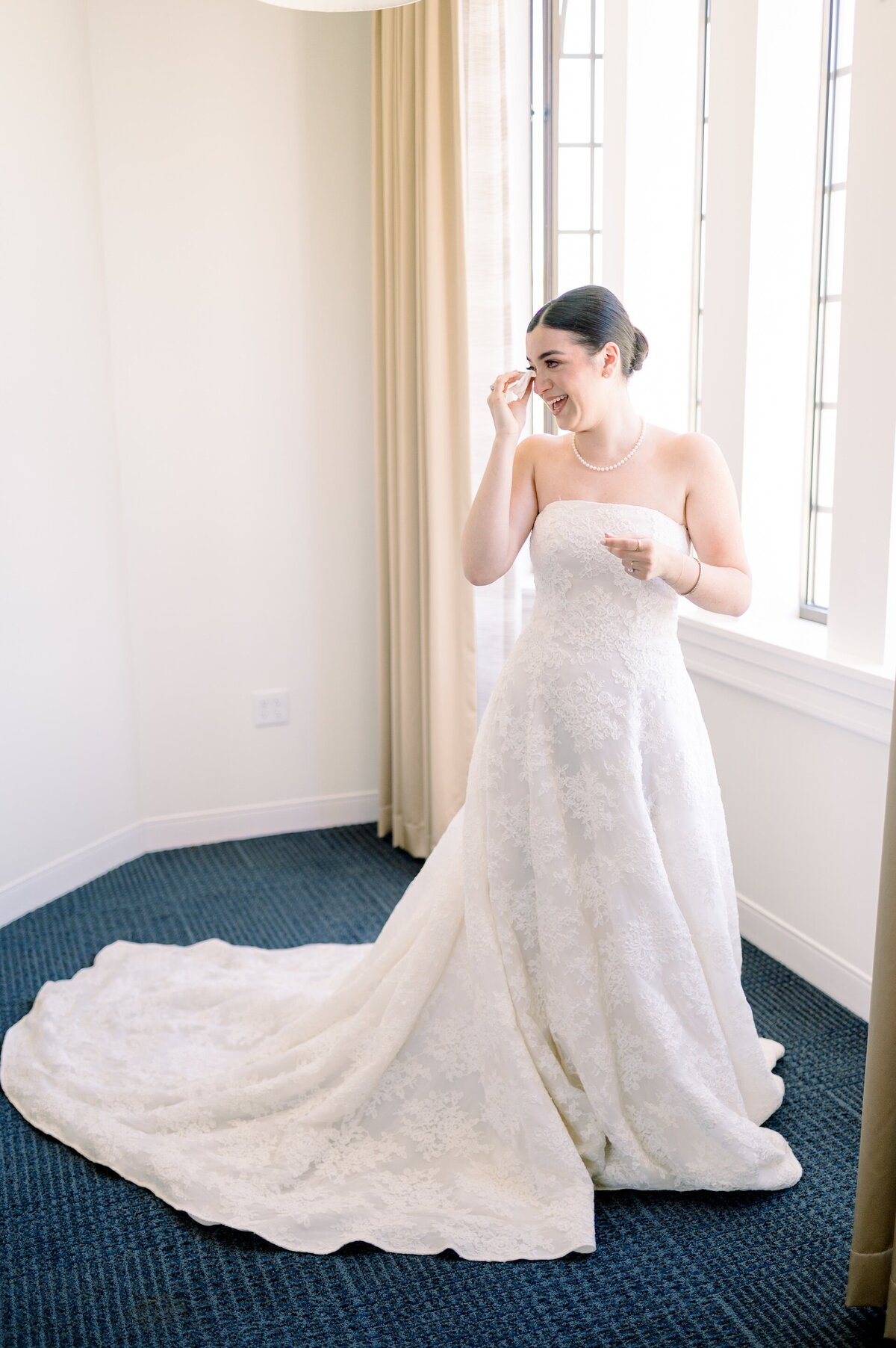 a bride tearing up after putting on her wedding dress