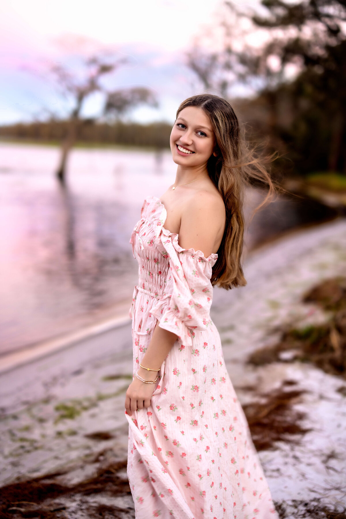 Senior flipping her hair at the beach during sunset session in Orlando, Florida