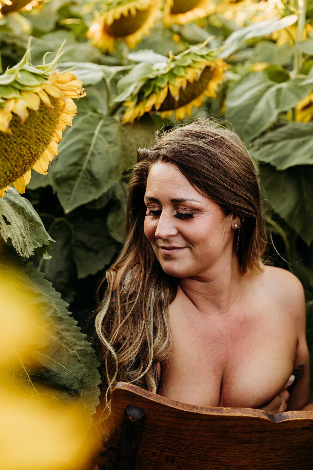 gorgeous women sitting topless and hugging herself in sunflowers in Green Bay