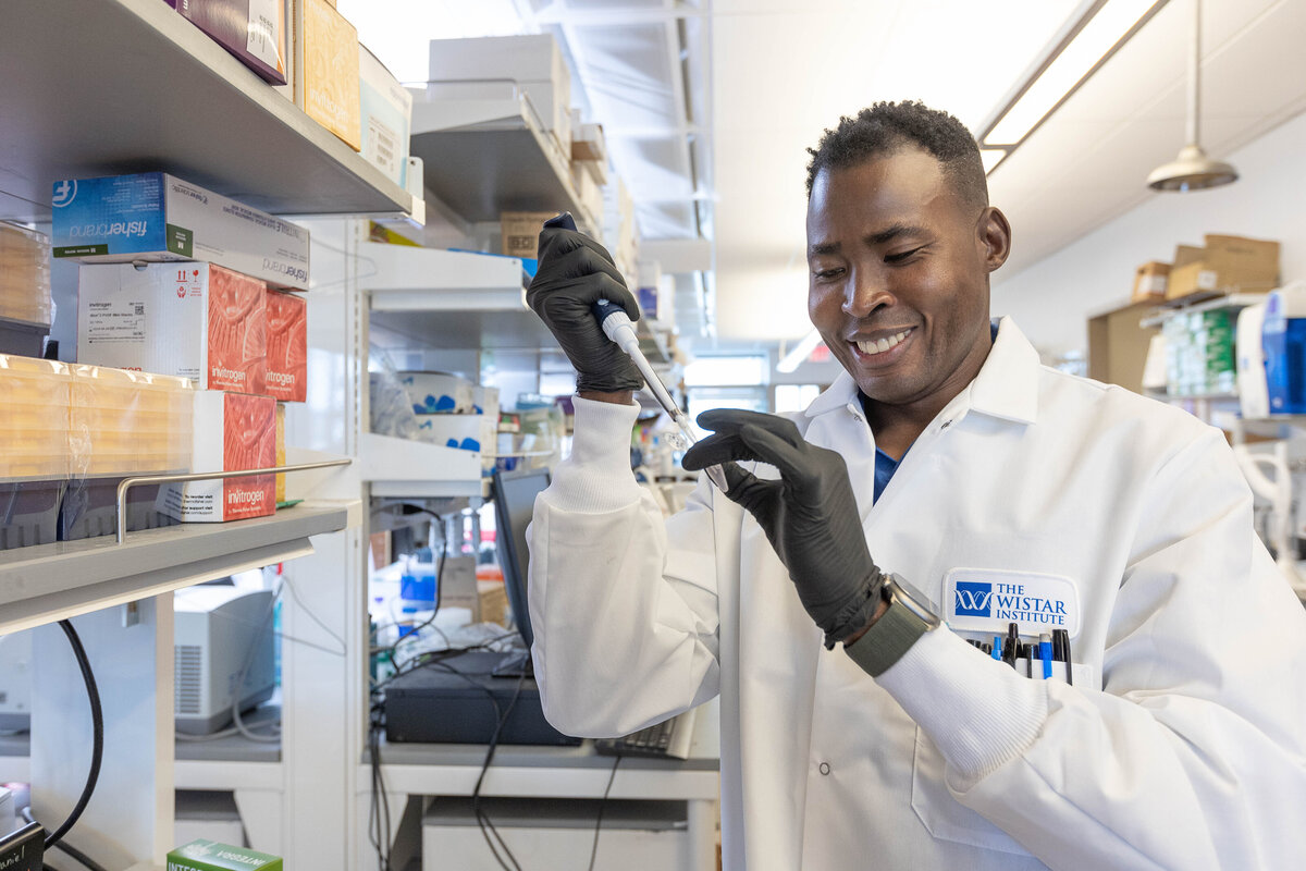 African American male scientist pipetting liquid into a test tube