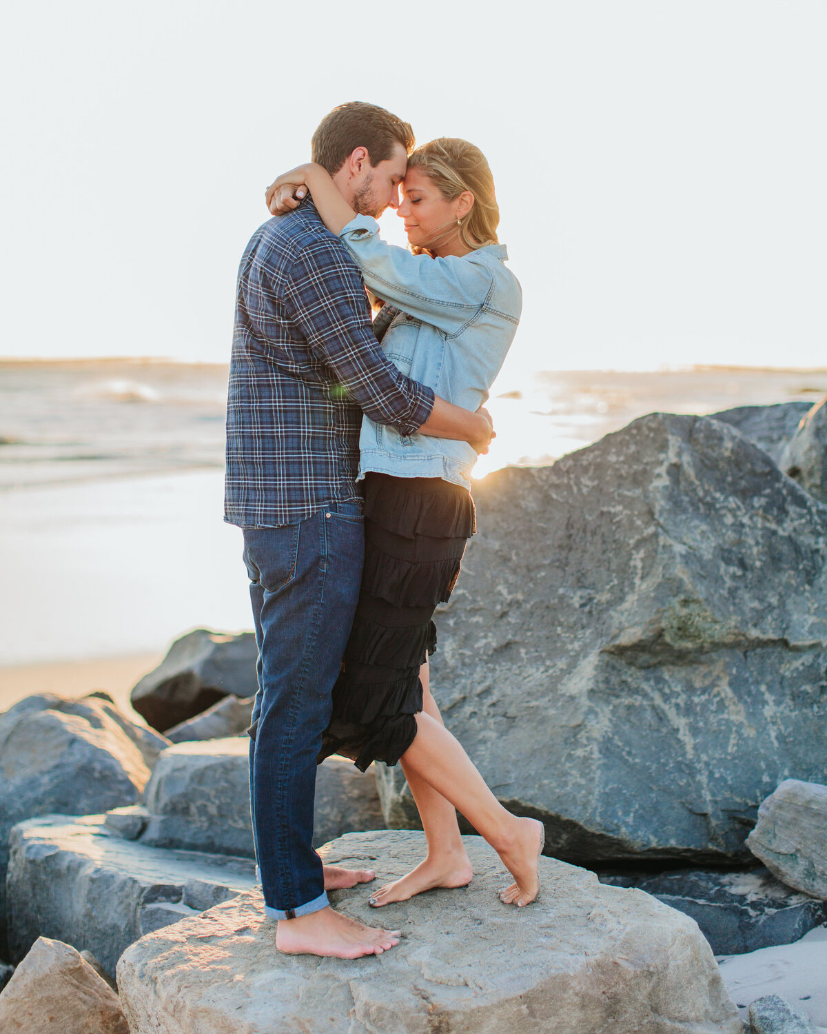 A couple with their arms wrapped around each other and foreheads together 