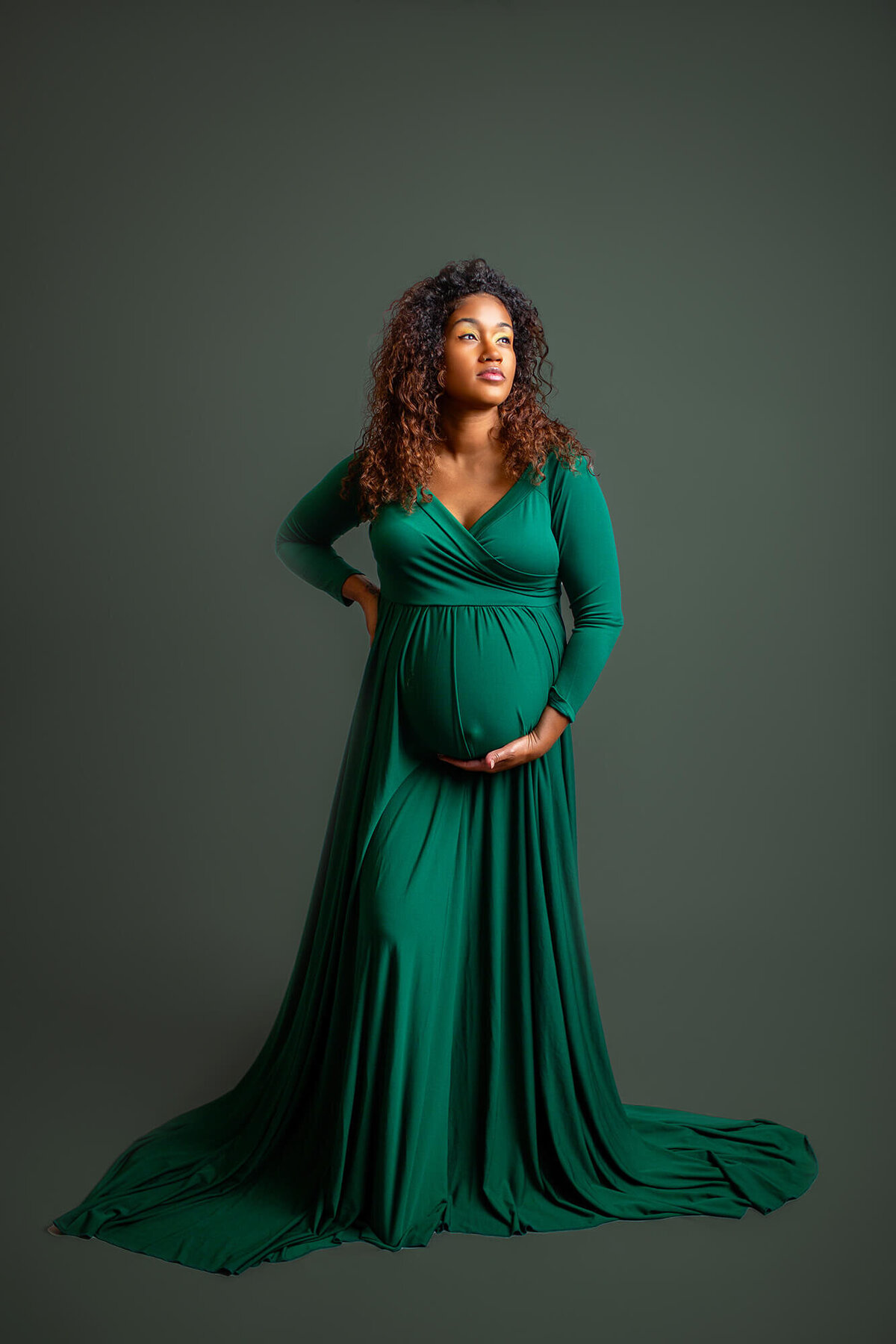 Deep green dress in classic maternity studio session. Studio located in Tampa, FL