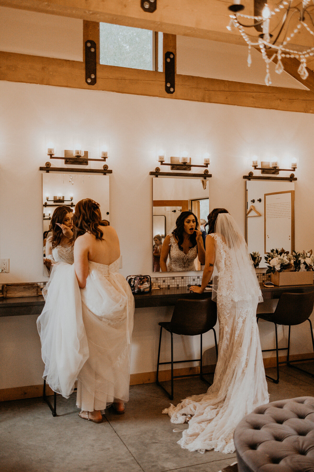 two brides doing final touch ups before their wedding ceremony