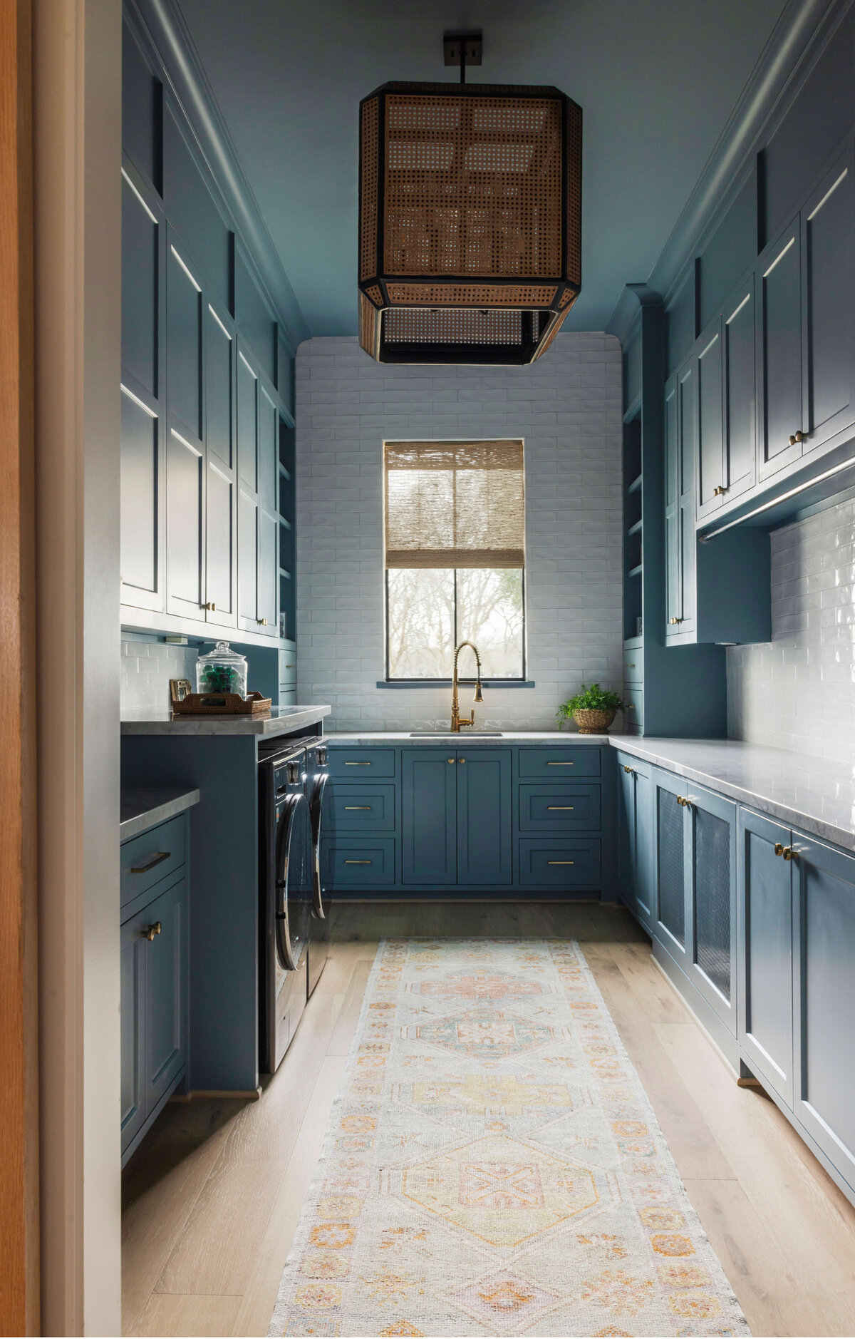 oyster creek studios missouri city new build dark blue galley kitchen with wicker lamp and light runner rug