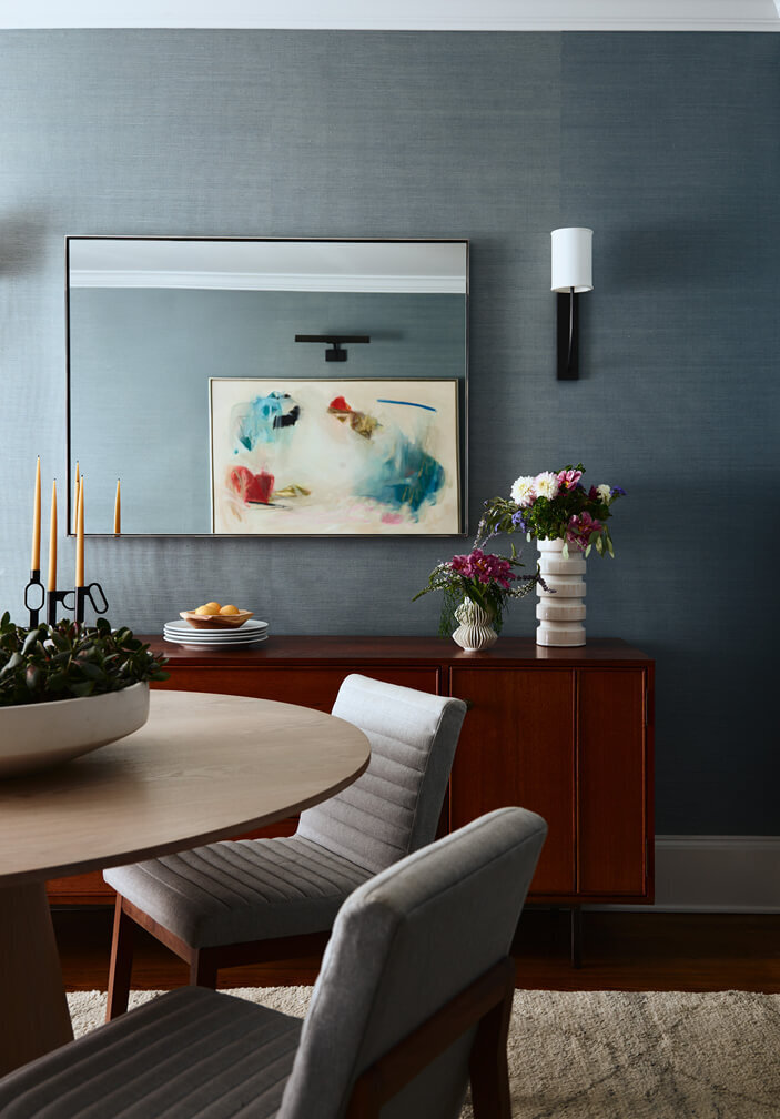 South Shore interior design creates a modern dining room with blue grasscloth wallpaper and contemporary art, blending bold design with timeless elegance.