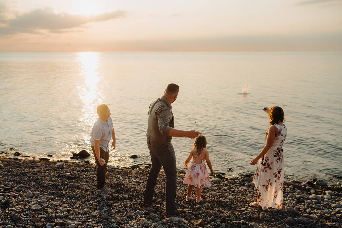Family on beach at sunset in Finger Lakes, NY
