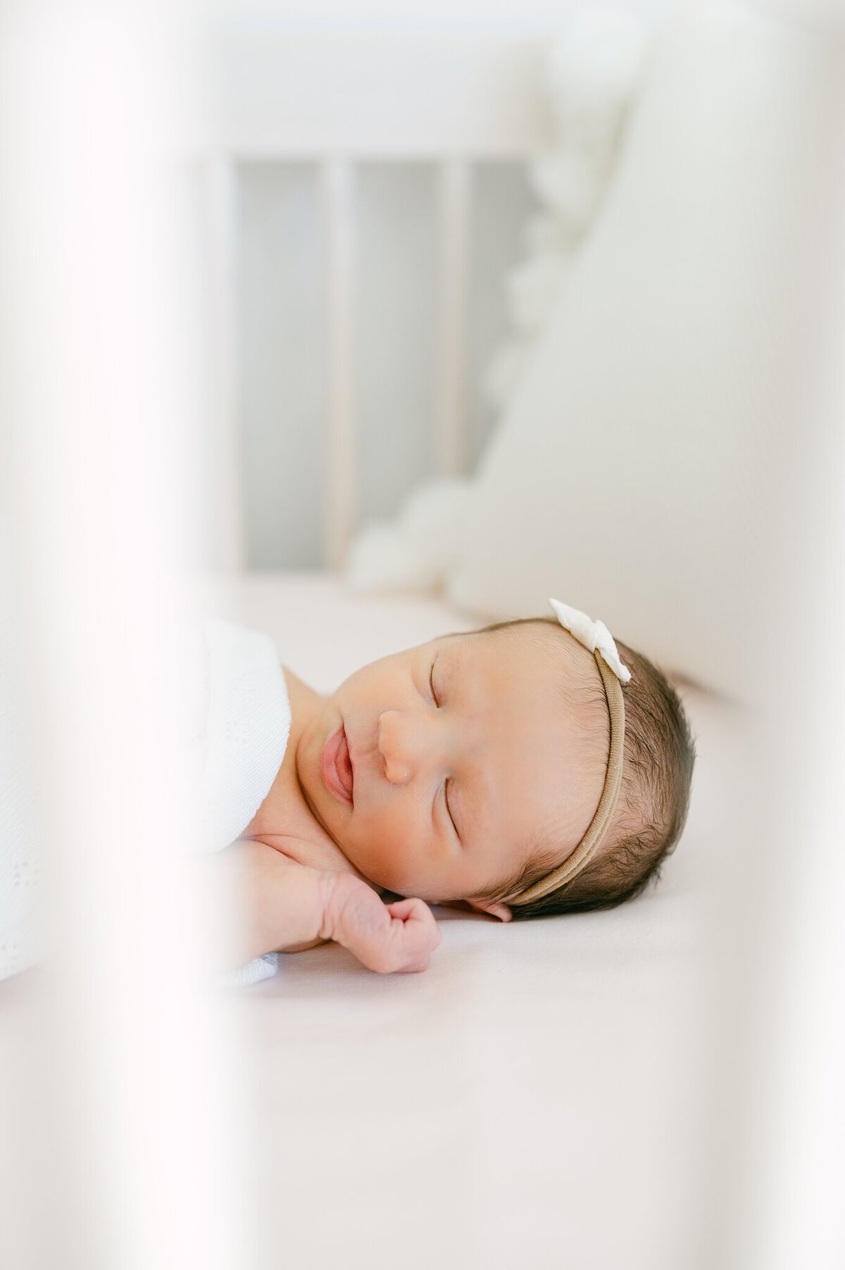 Close up of baby in the crib shot through the slats of the crib.