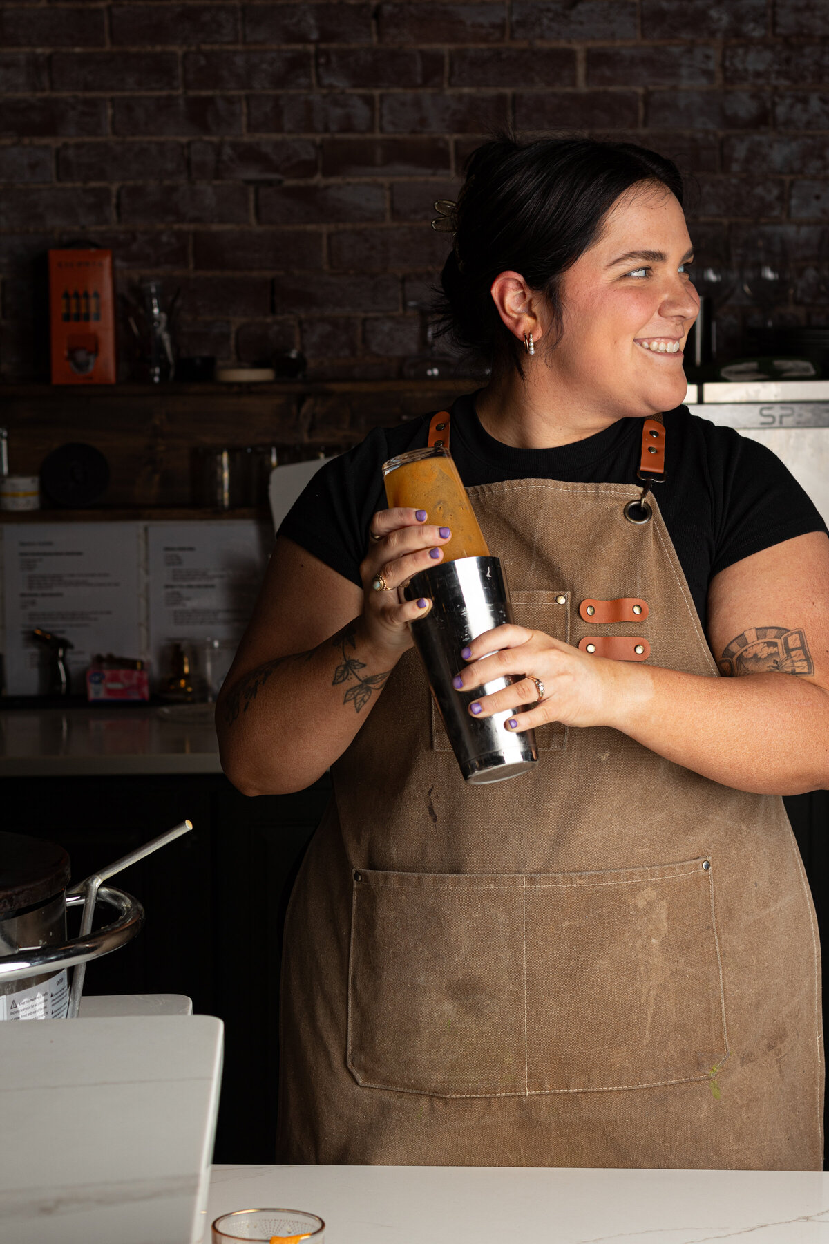  a woman shaking up a cocktail in a mixer