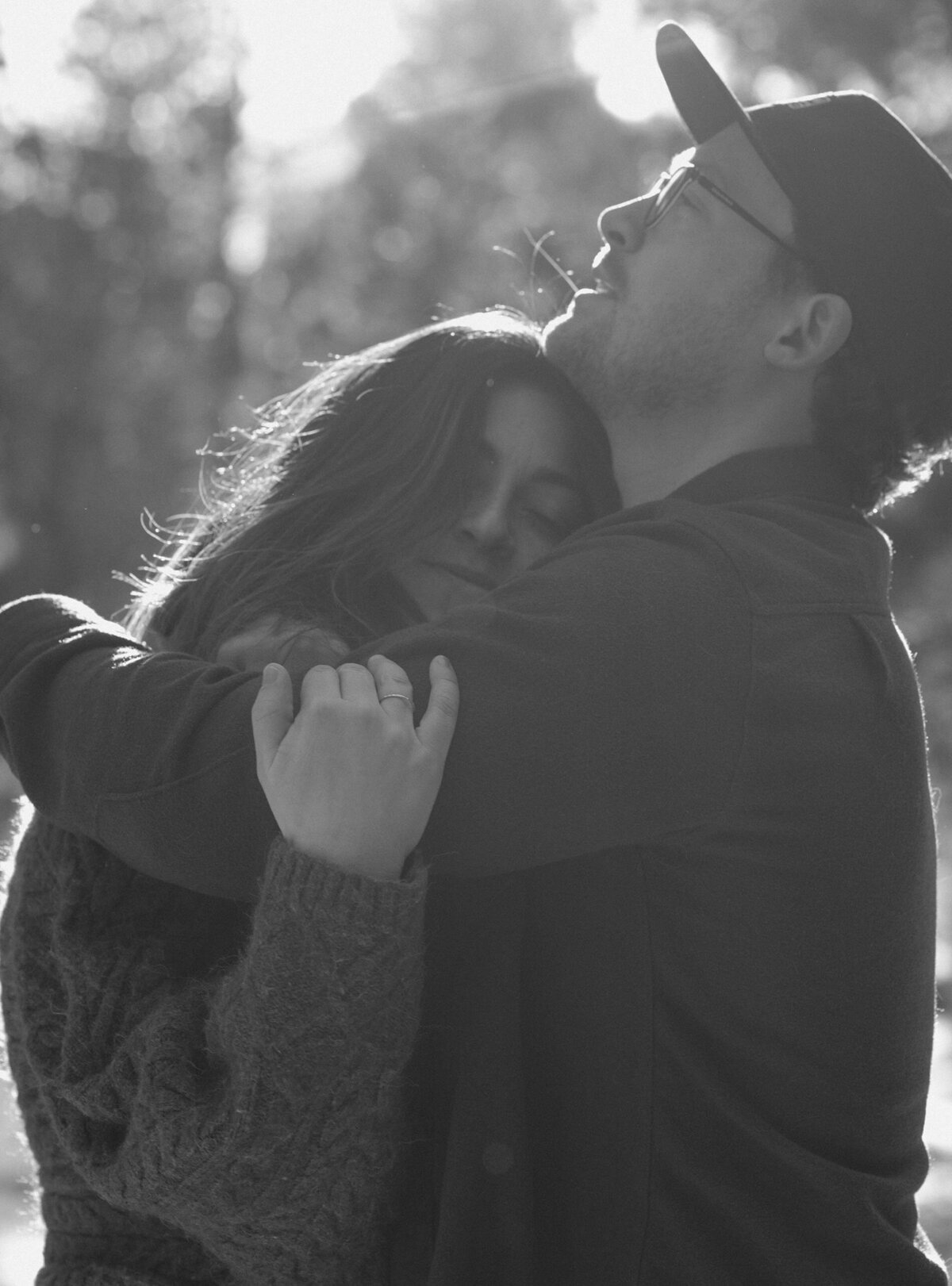 man and woman embrace in a hug while shooting in the snowy outdoors in central Oregon