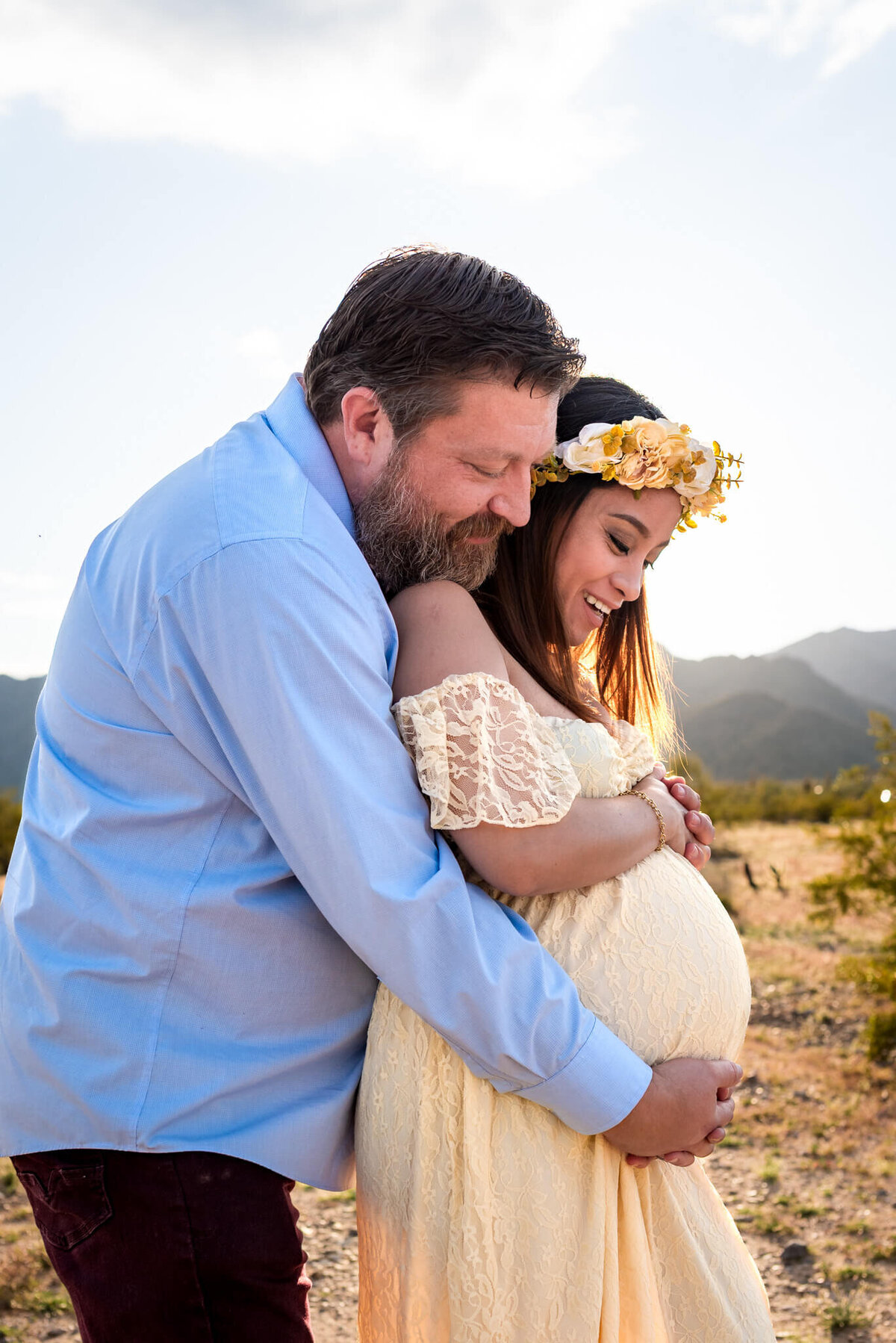 Husband hugs his expecting wife and her baby bump for Arizona maternity session