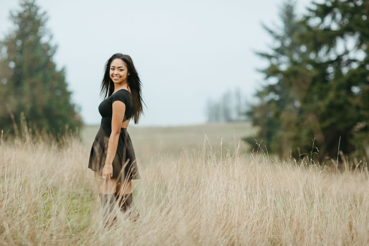Young woman standing at a grassy field at a  park.