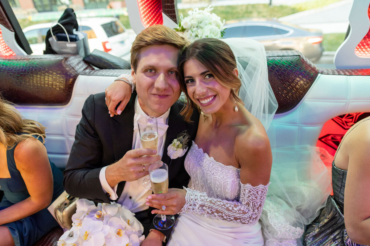 A bride and groom are posing for a picture while holding champagne glasses