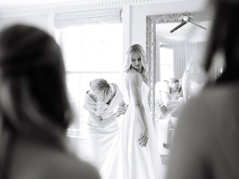 Bride being zipped up by family member to show planning a wedding in chicago