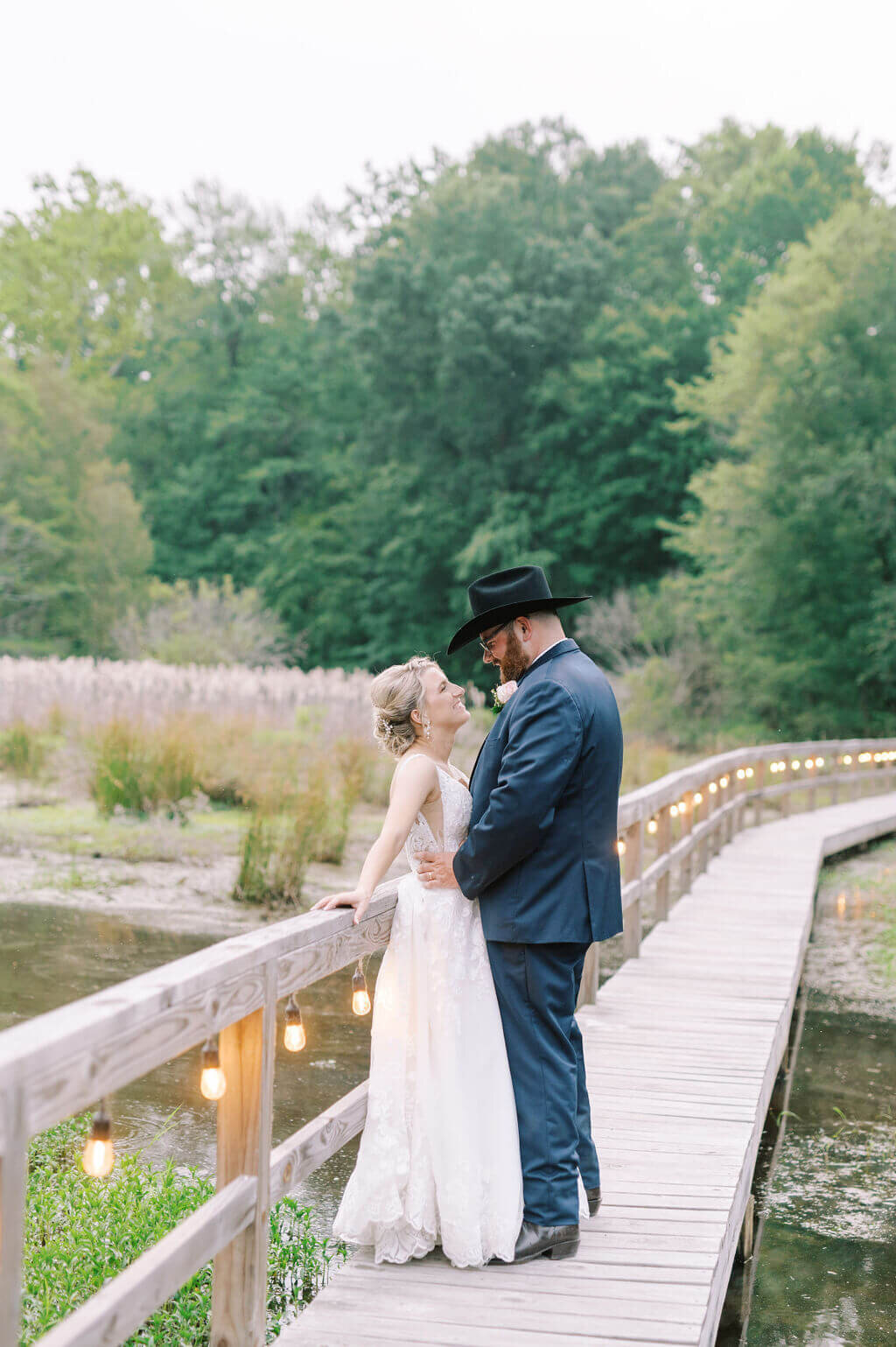 bride and groom looking at each other on a pier on the water