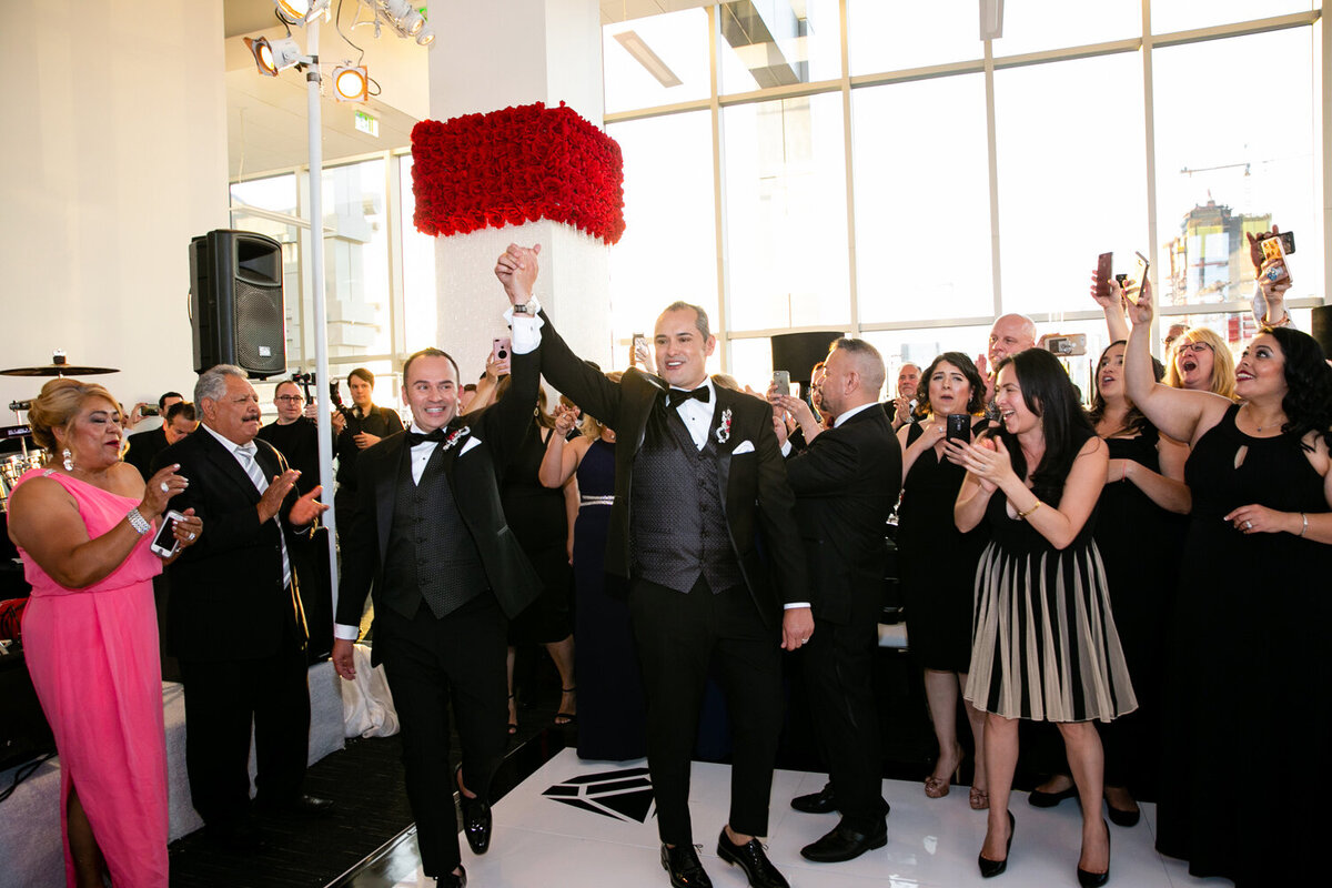 Guests celebrating as grooms walk out